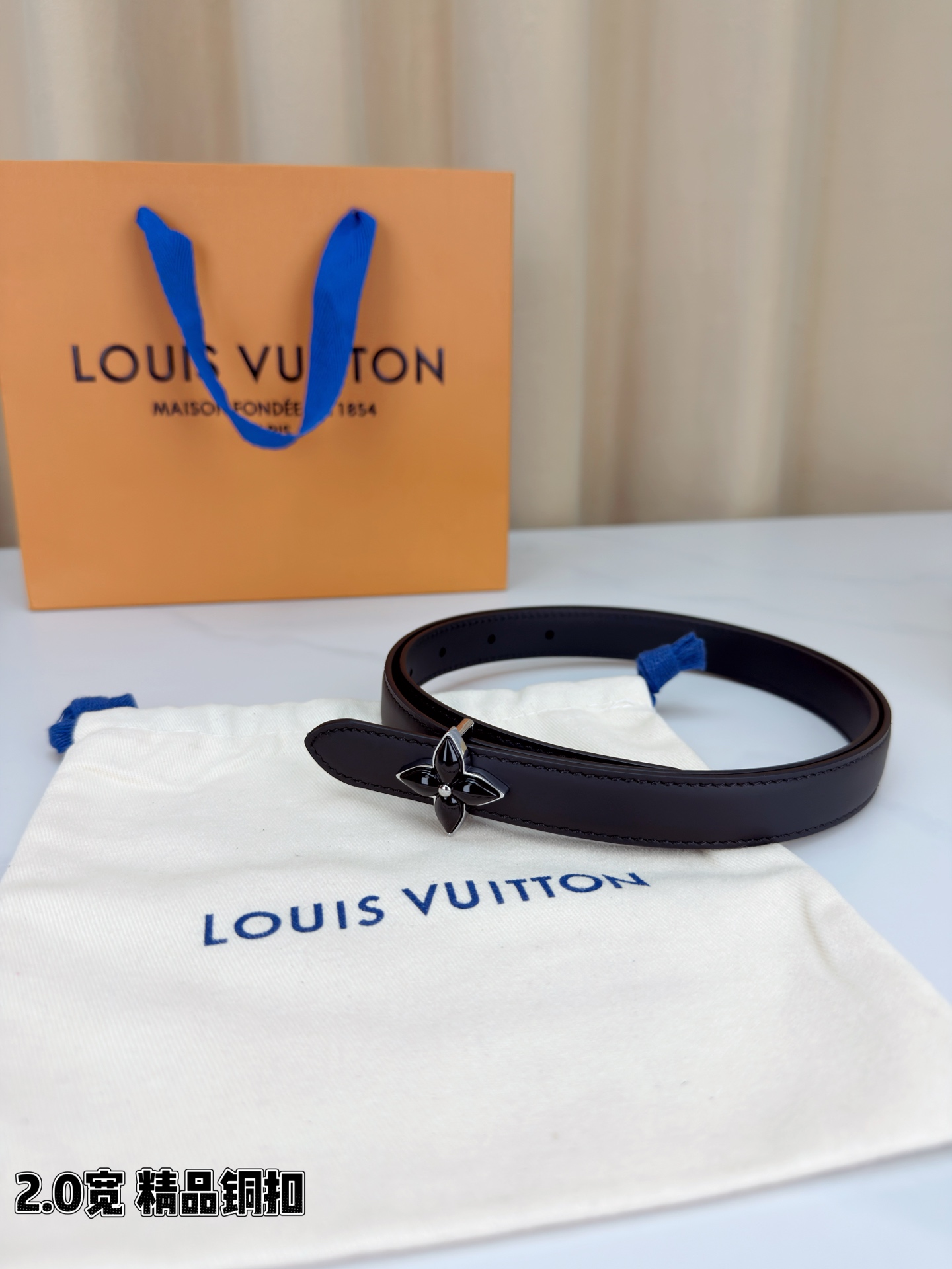 路易威登2.0宽细腰带，四叶花铜扣缀以金色包边，中心金属珠灵动点睛。红黑双色可选，皮革细腻柔软，同色缝线