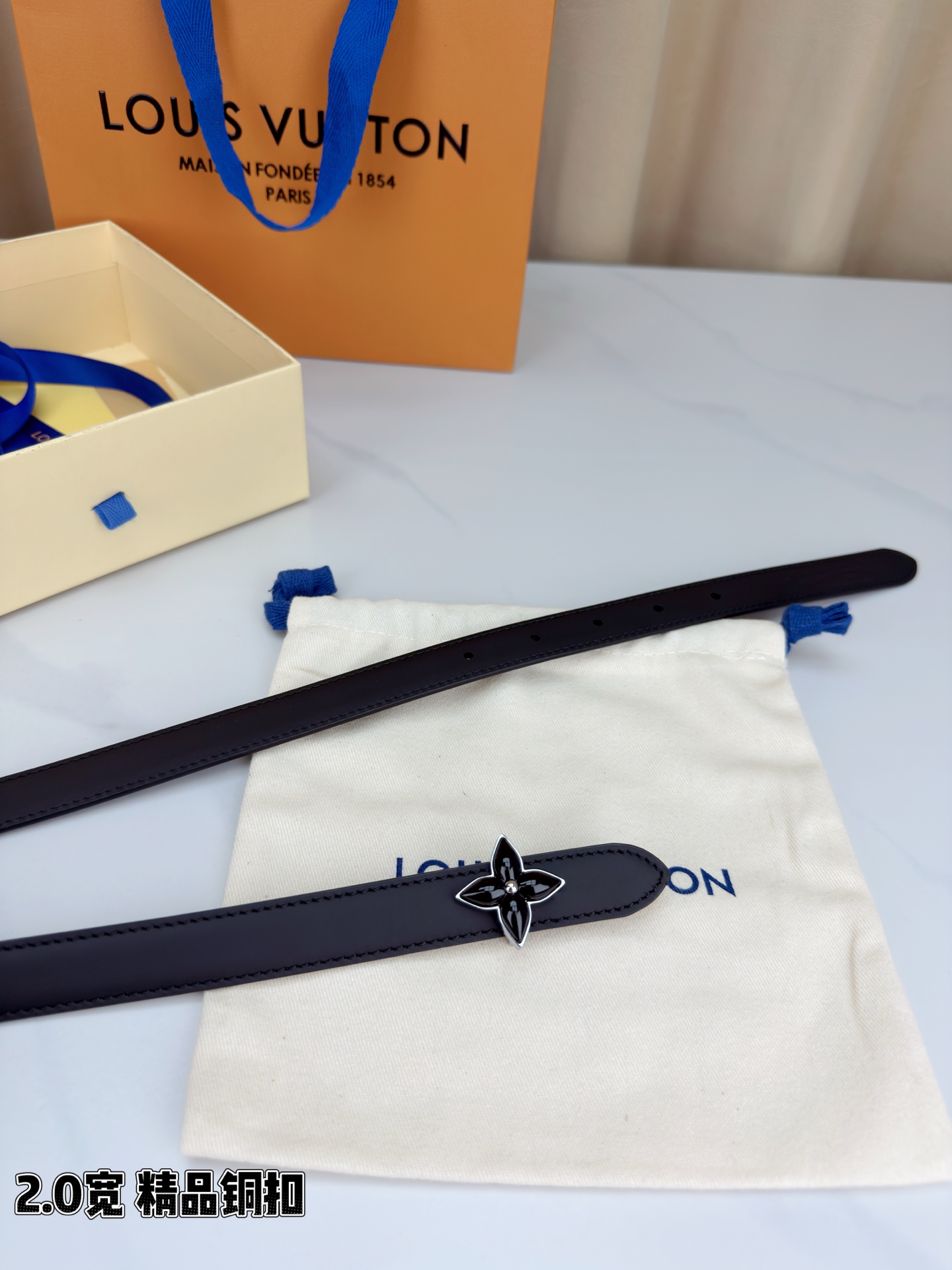 路易威登2.0宽细腰带，四叶花铜扣缀以金色包边，中心金属珠灵动点睛。红黑双色可选，皮革细腻柔软，同色缝线