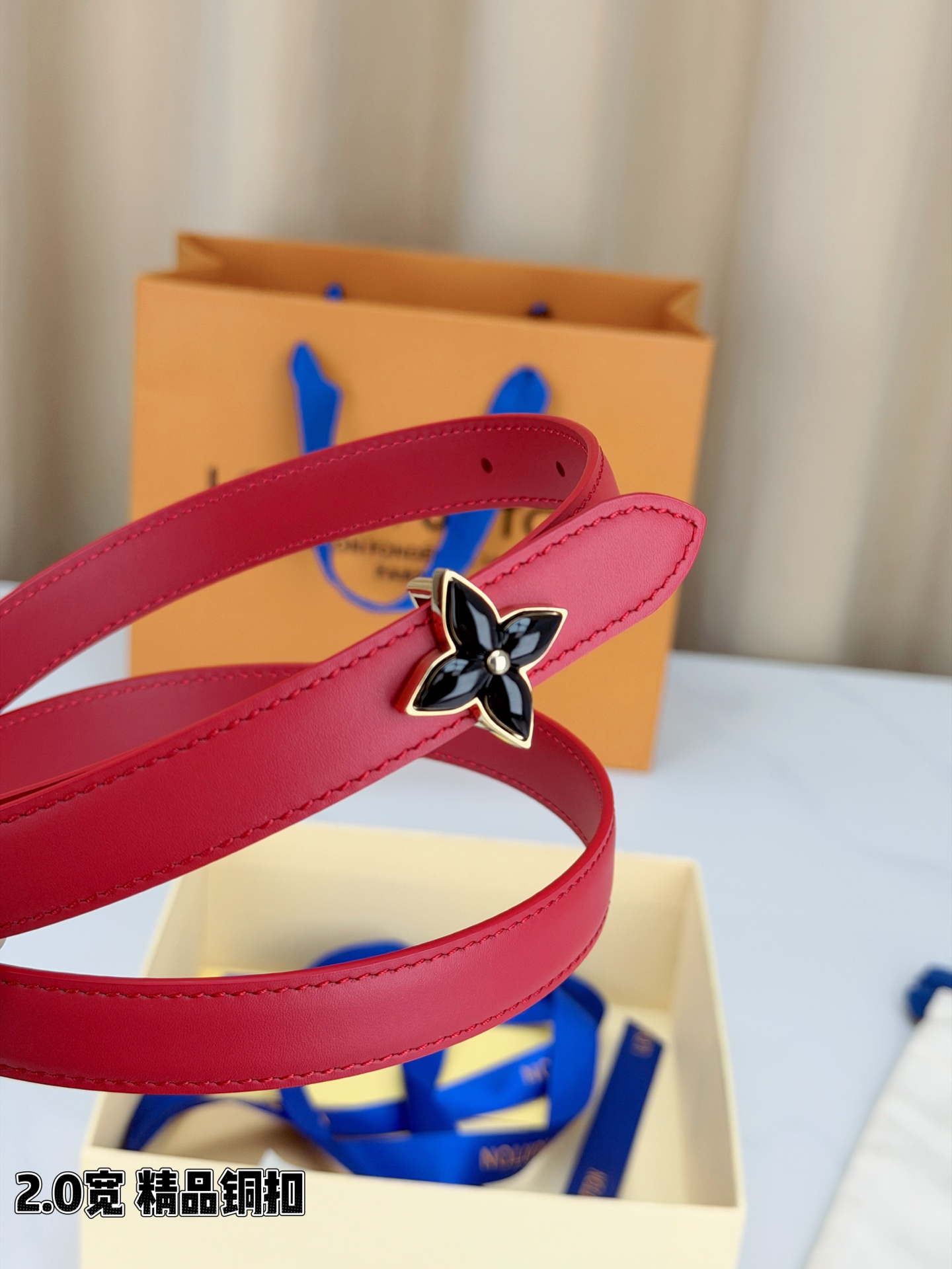 路易威登2.0宽细腰带，四叶花铜扣缀以金色包边，中心金属珠灵动点睛。红黑双色可选，皮革细腻柔软，同色缝线