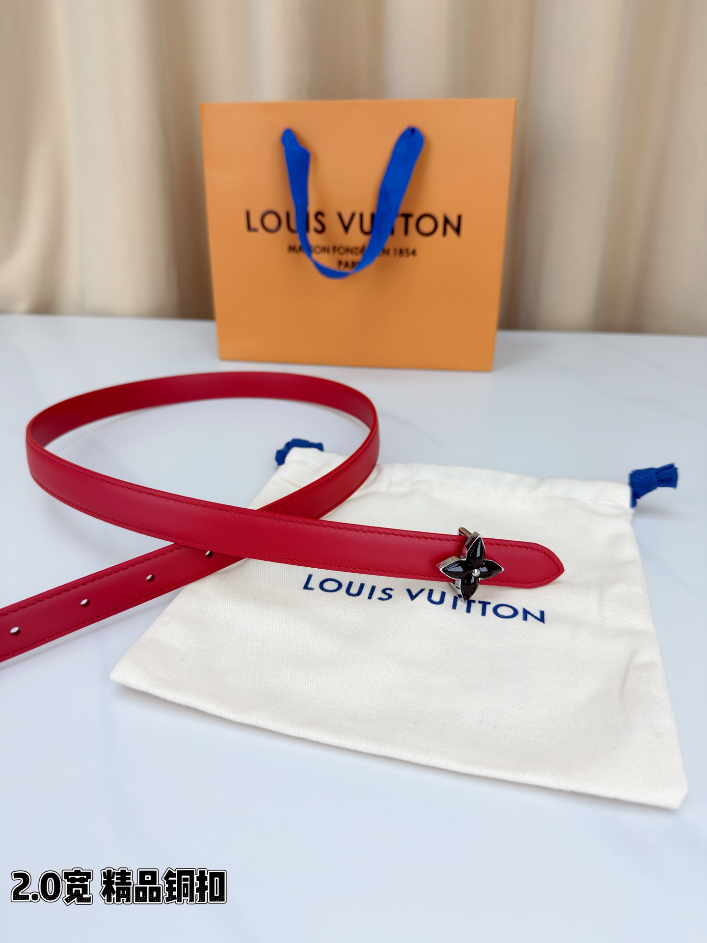 路易威登2.0宽细腰带，四叶花铜扣缀以金色包边，中心金属珠灵动点睛。红黑双色可选，皮革细腻柔软，同色缝线