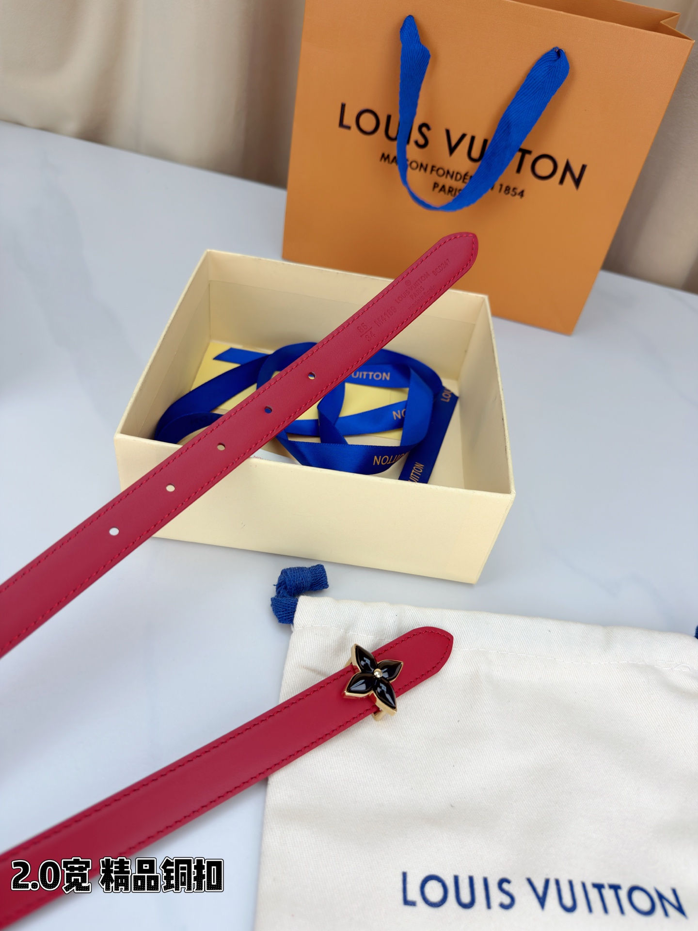路易威登2.0宽细腰带，四叶花铜扣缀以金色包边，中心金属珠灵动点睛。红黑双色可选，皮革细腻柔软，同色缝线