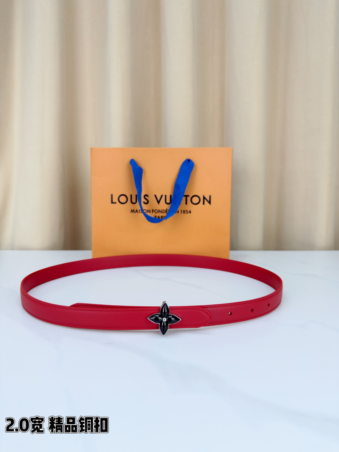 路易威登2.0宽细腰带，四叶花铜扣缀以金色包边，中心金属珠灵动点睛。红黑双色可选，皮革细腻柔软，同色缝线