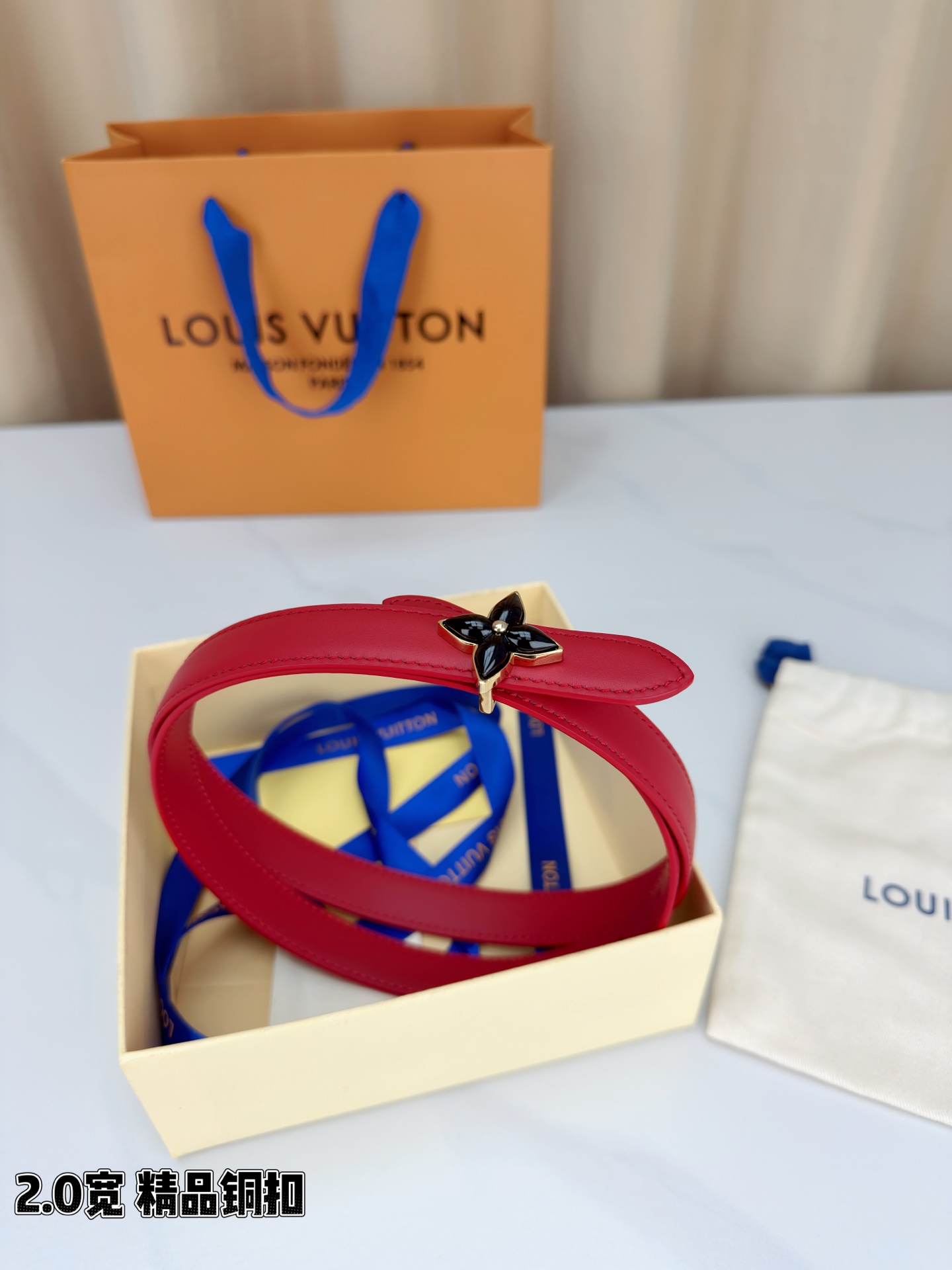 路易威登2.0宽细腰带，四叶花铜扣缀以金色包边，中心金属珠灵动点睛。红黑双色可选，皮革细腻柔软，同色缝线