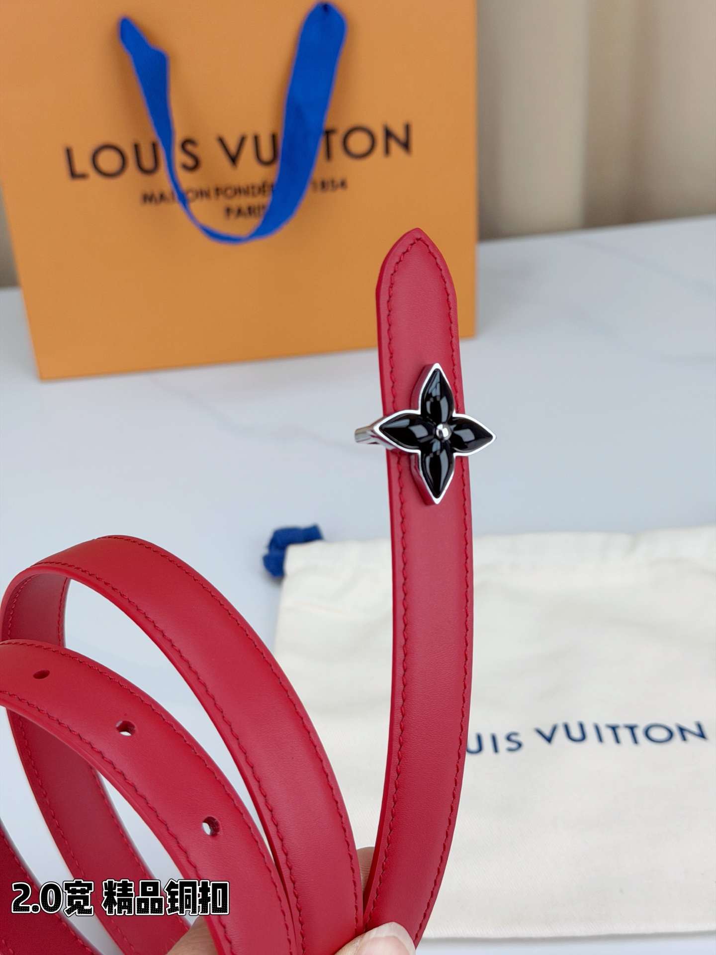 路易威登2.0宽细腰带，四叶花铜扣缀以金色包边，中心金属珠灵动点睛。红黑双色可选，皮革细腻柔软，同色缝线