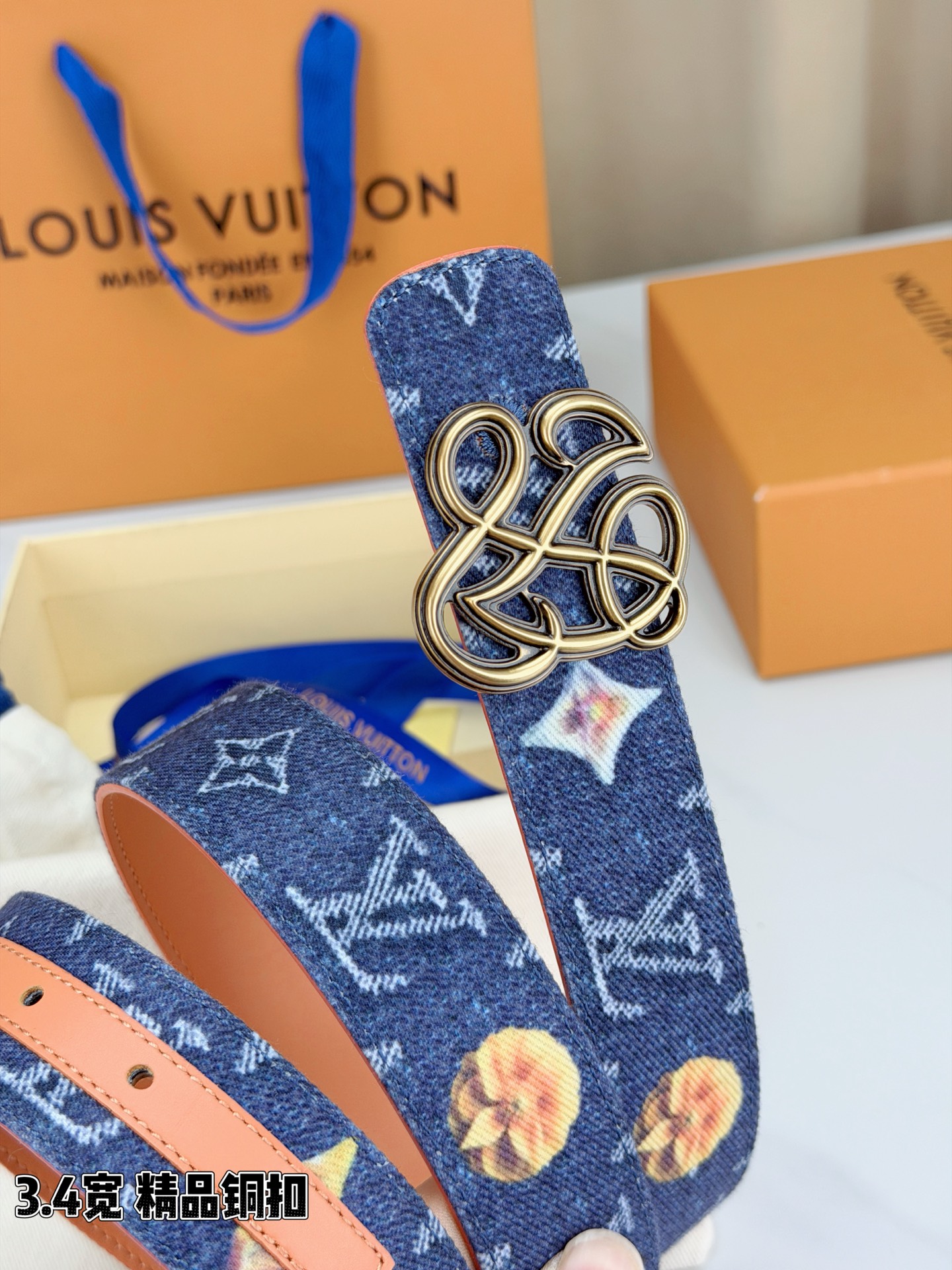 路易威登3.4宽腰带，深蓝牛仔肌理缀以橙黄花朵印花，法式浪漫悄然绽放。镂空铜扣线条交织，金银古白 古金 