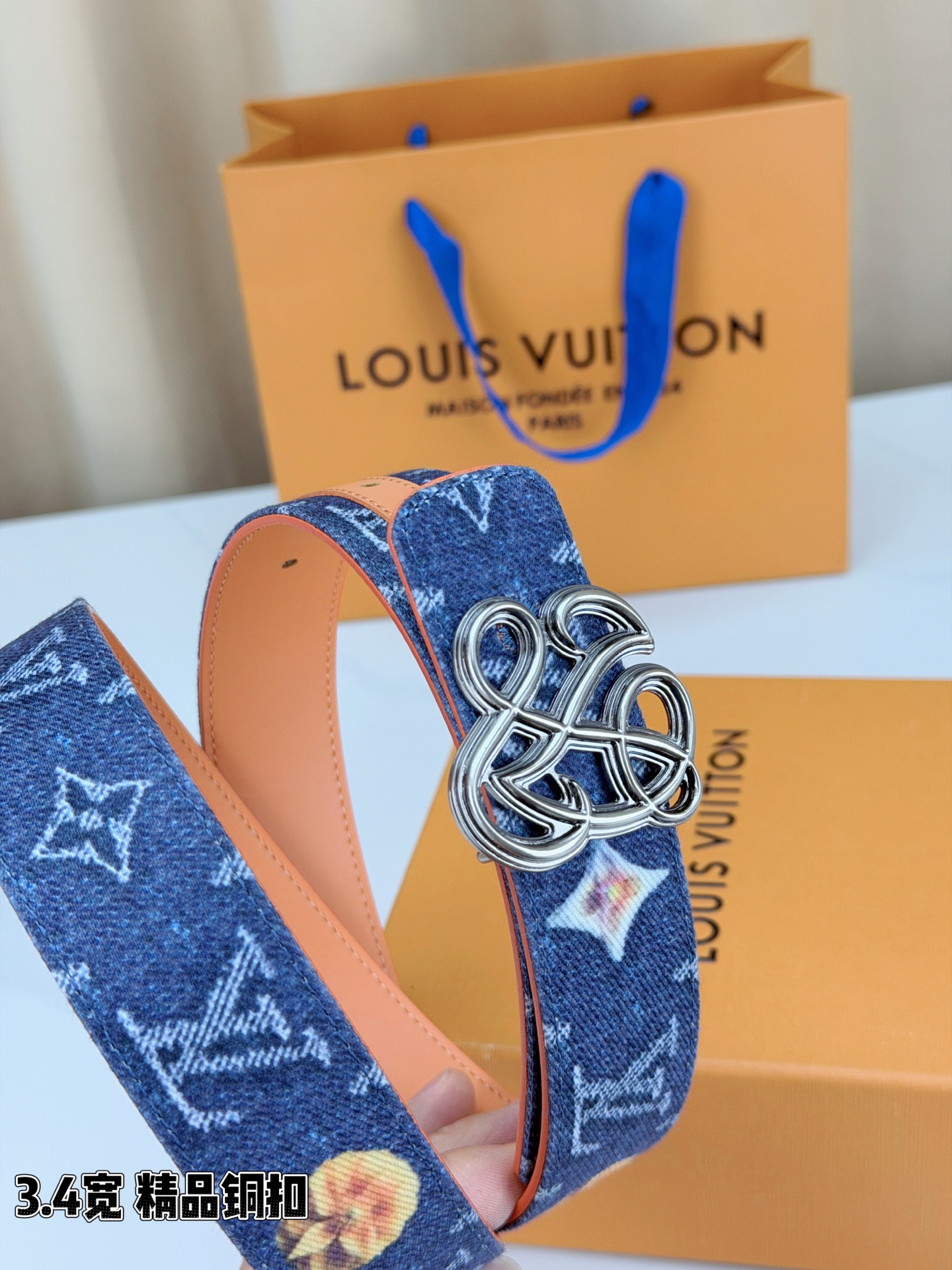 路易威登3.4宽腰带，深蓝牛仔肌理缀以橙黄花朵印花，法式浪漫悄然绽放。镂空铜扣线条交织，金银古白 古金 