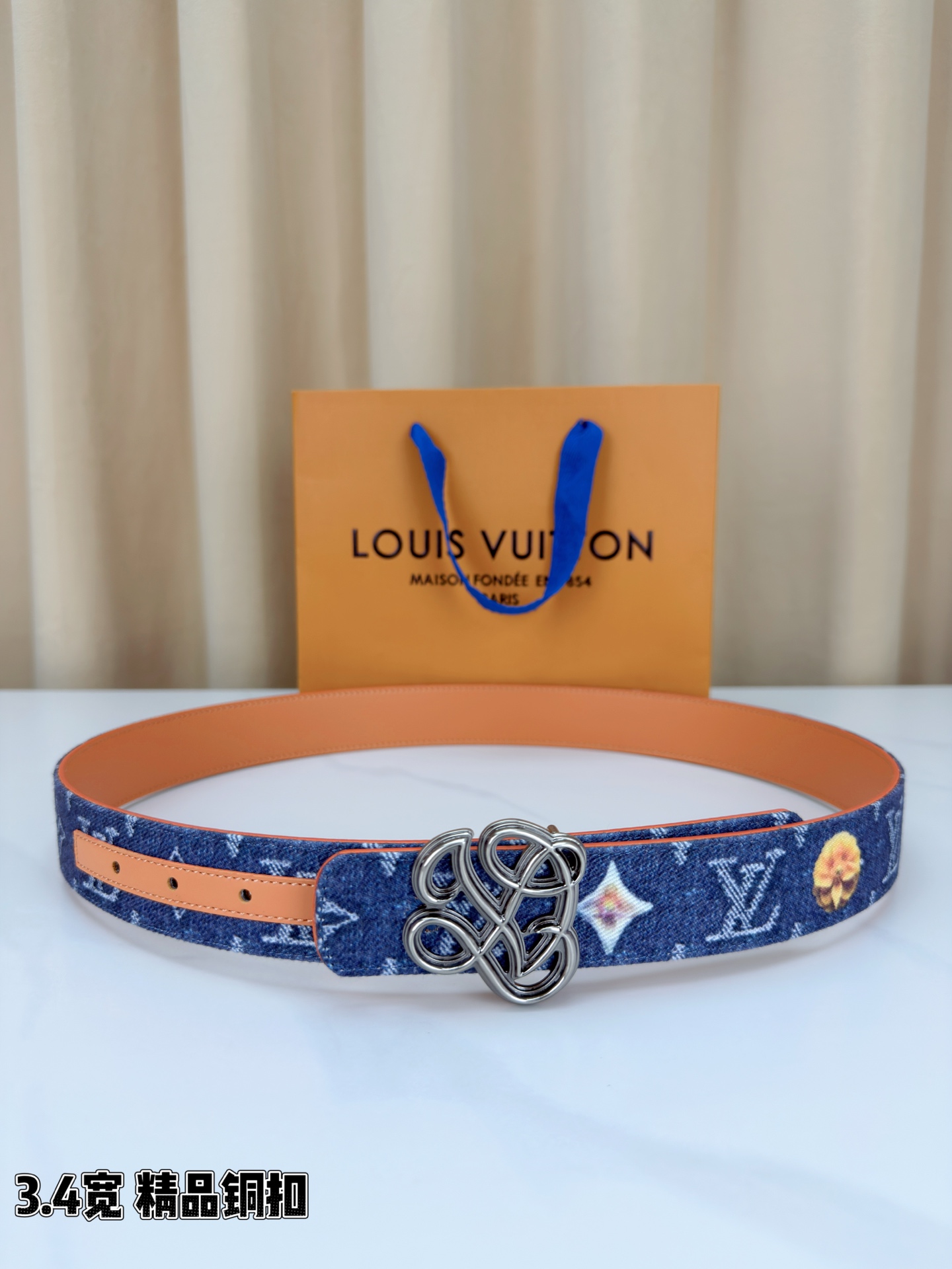路易威登3.4宽腰带，深蓝牛仔肌理缀以橙黄花朵印花，法式浪漫悄然绽放。镂空铜扣线条交织，金银古白 古金 