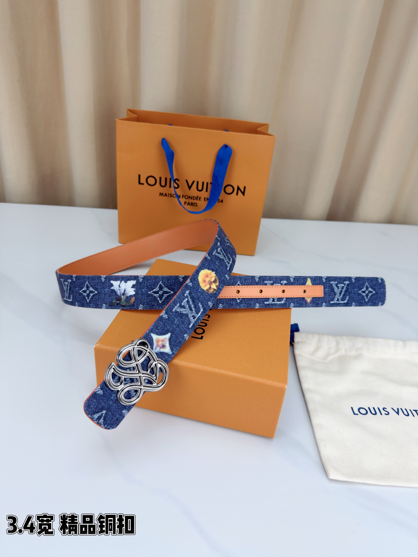 路易威登3.4宽腰带，深蓝牛仔肌理缀以橙黄花朵印花，法式浪漫悄然绽放。镂空铜扣线条交织，金银古白 古金 