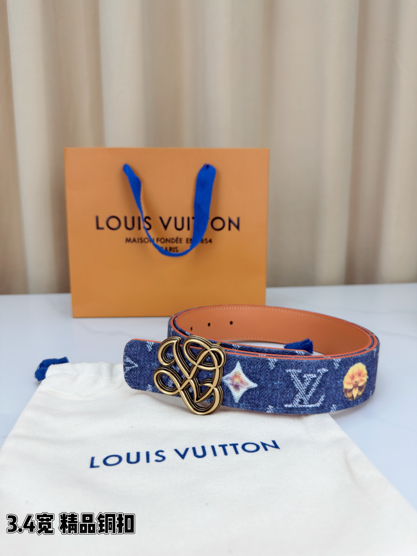 路易威登3.4宽腰带，深蓝牛仔肌理缀以橙黄花朵印花，法式浪漫悄然绽放。镂空铜扣线条交织，金银古白 古金 