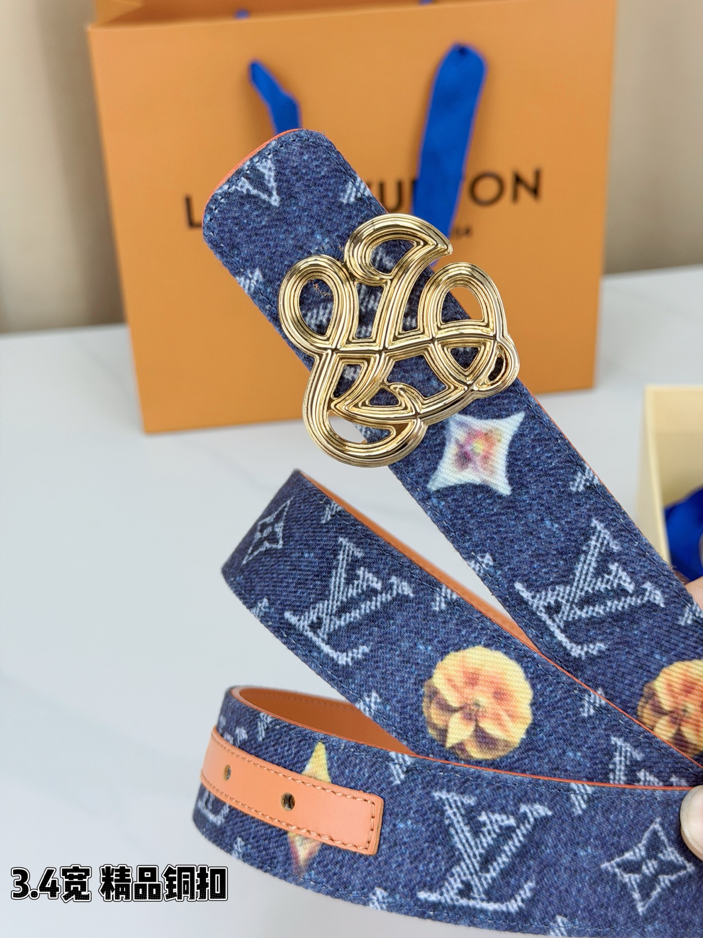 路易威登3.4宽腰带，深蓝牛仔肌理缀以橙黄花朵印花，法式浪漫悄然绽放。镂空铜扣线条交织，金银古白 古金 