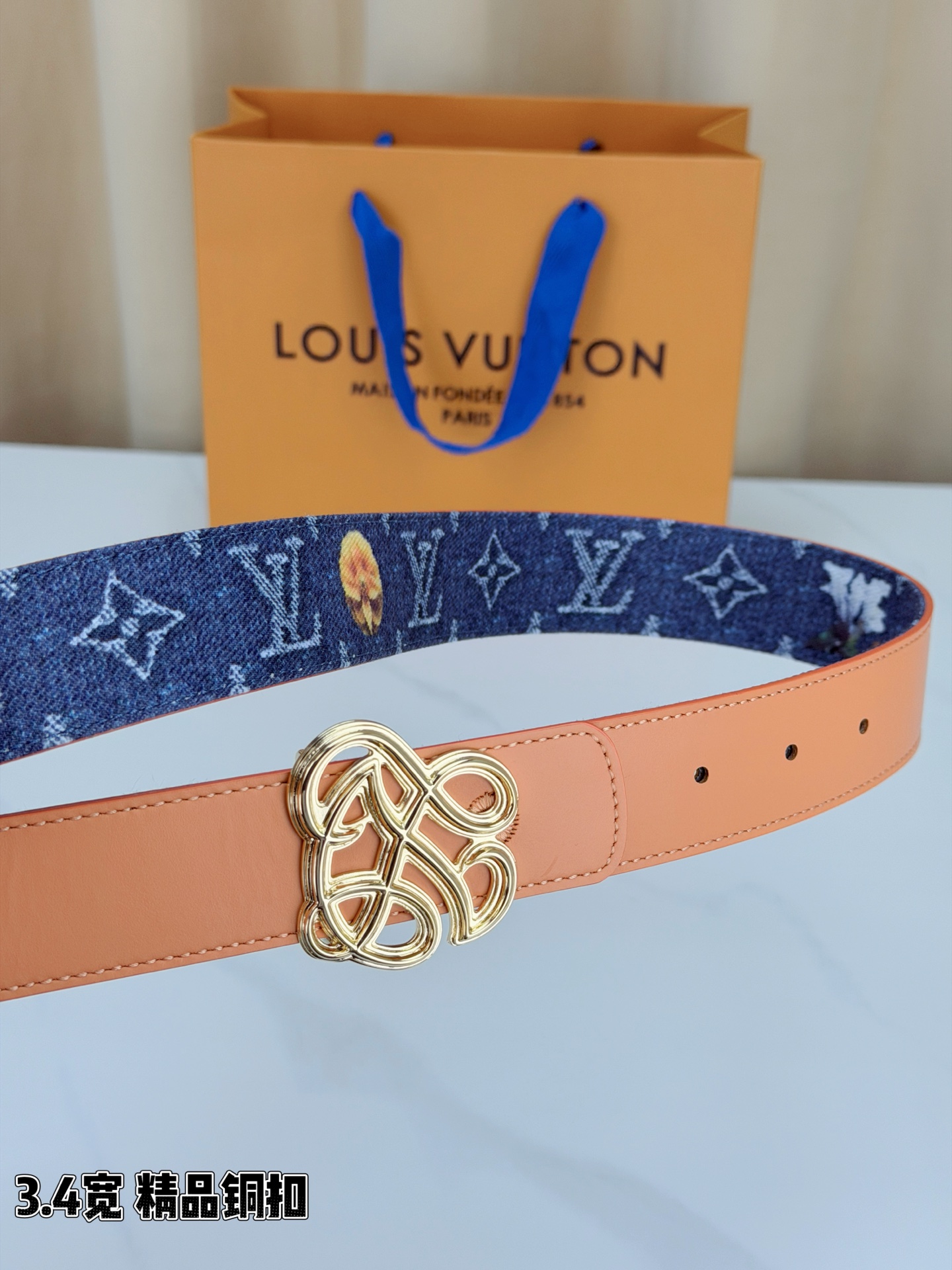 路易威登3.4宽腰带，深蓝牛仔肌理缀以橙黄花朵印花，法式浪漫悄然绽放。镂空铜扣线条交织，金银古白 古金 