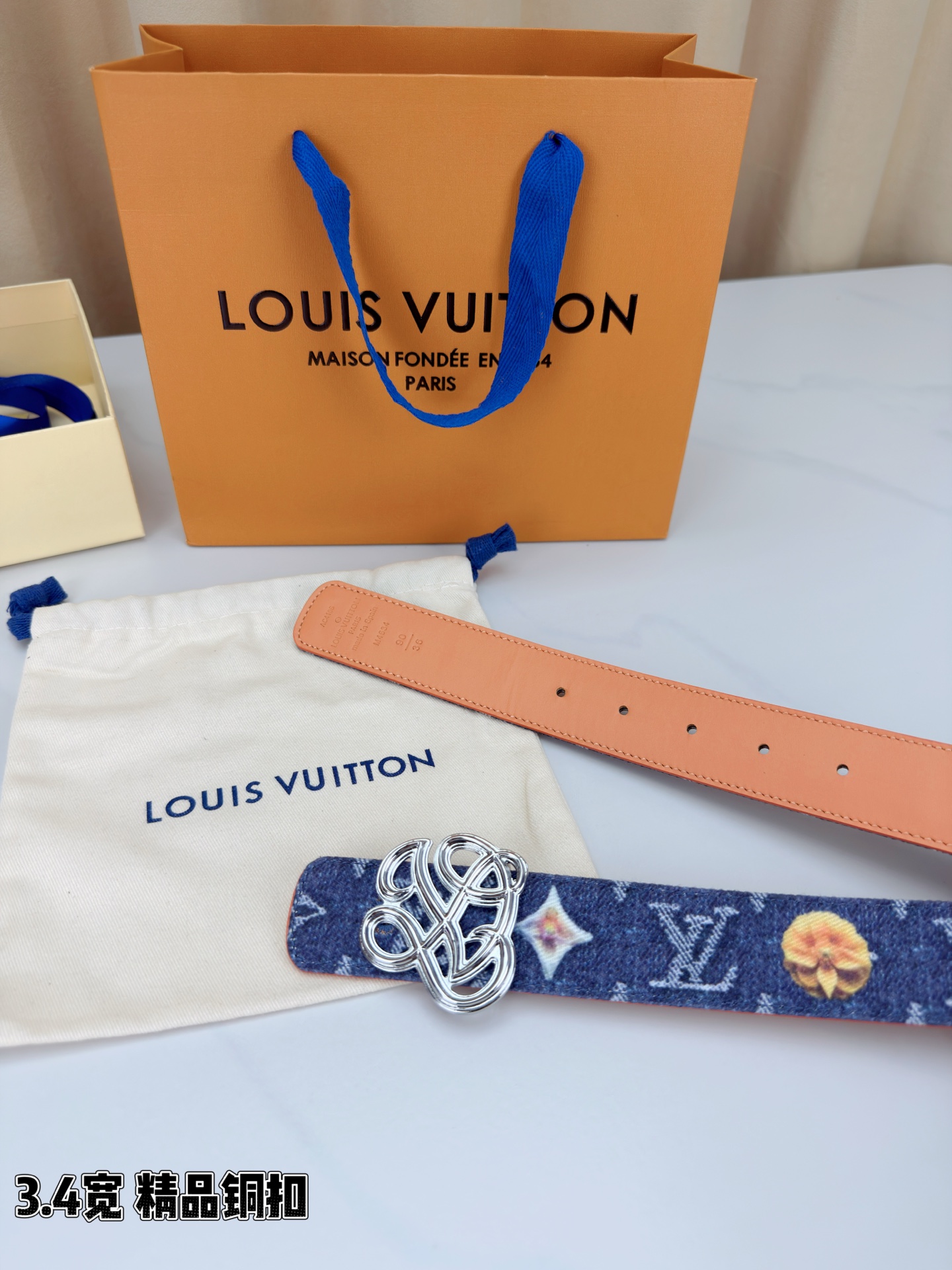 路易威登3.4宽腰带，深蓝牛仔肌理缀以橙黄花朵印花，法式浪漫悄然绽放。镂空铜扣线条交织，金银古白 古金 