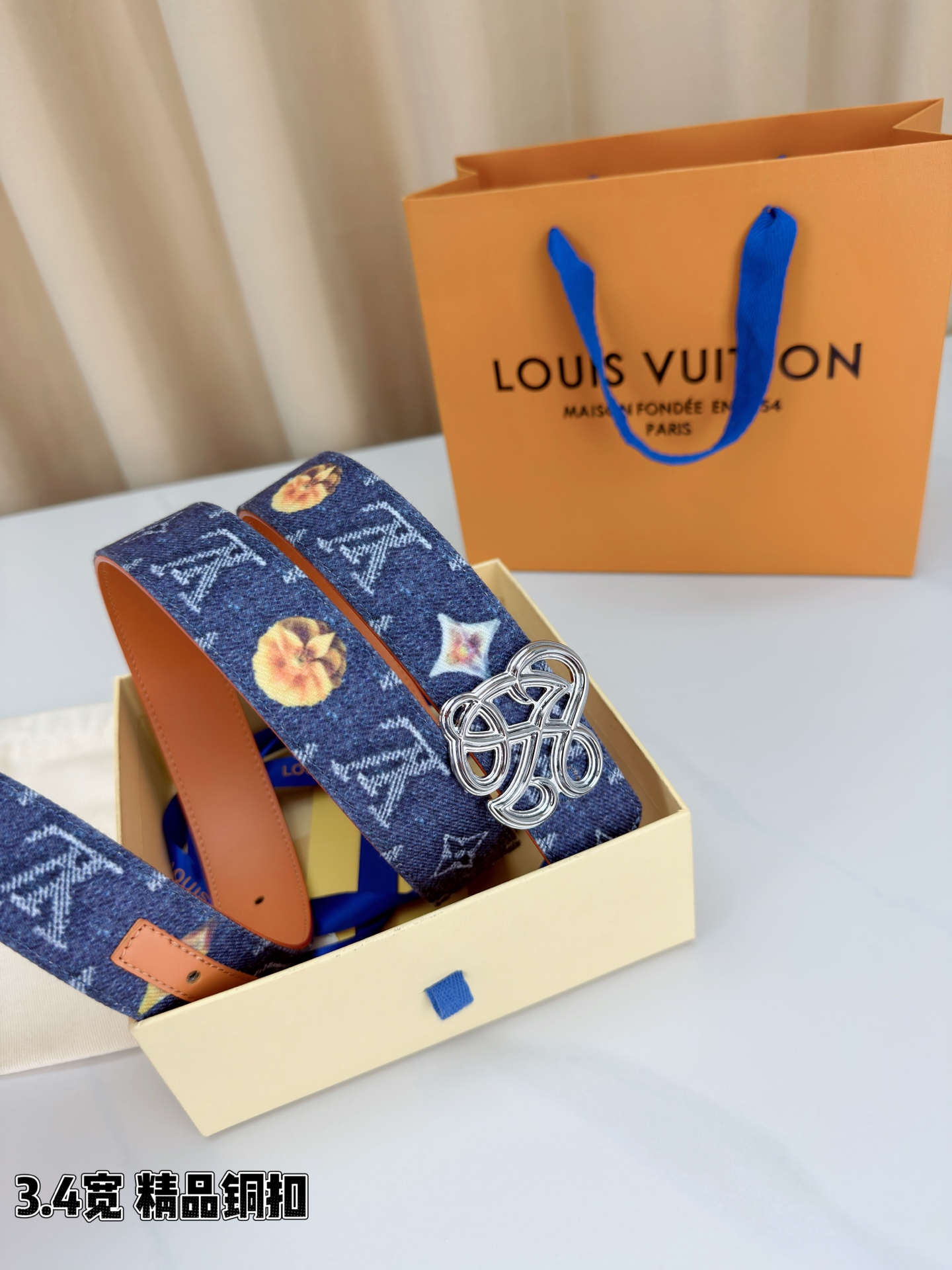 路易威登3.4宽腰带，深蓝牛仔肌理缀以橙黄花朵印花，法式浪漫悄然绽放。镂空铜扣线条交织，金银古白 古金 