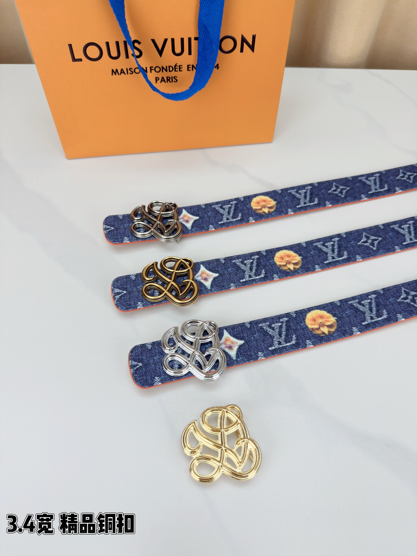 路易威登3.4宽腰带，深蓝牛仔肌理缀以橙黄花朵印花，法式浪漫悄然绽放。镂空铜扣线条交织，金银古白 古金 