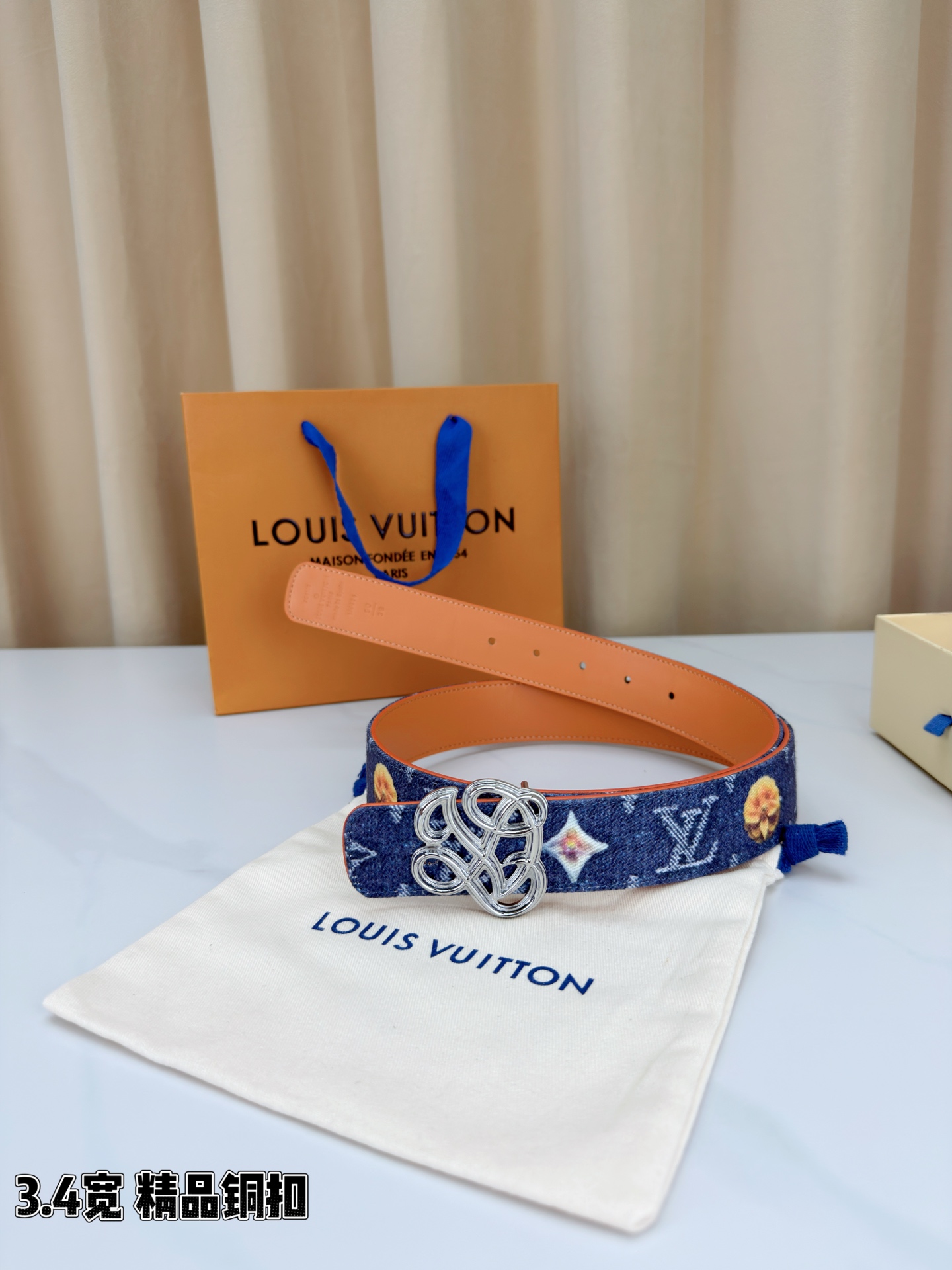 路易威登3.4宽腰带，深蓝牛仔肌理缀以橙黄花朵印花，法式浪漫悄然绽放。镂空铜扣线条交织，金银古白 古金 