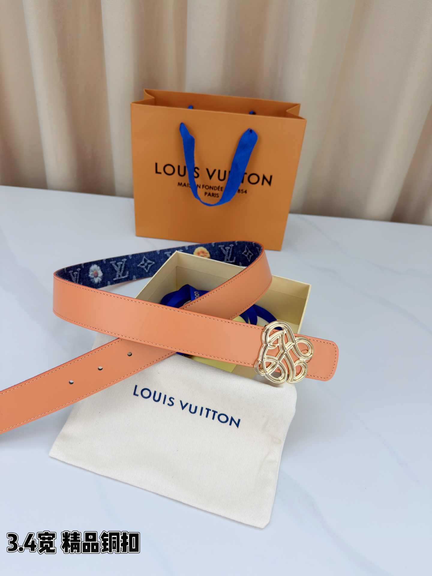 路易威登3.4宽腰带，深蓝牛仔肌理缀以橙黄花朵印花，法式浪漫悄然绽放。镂空铜扣线条交织，金银古白 古金 