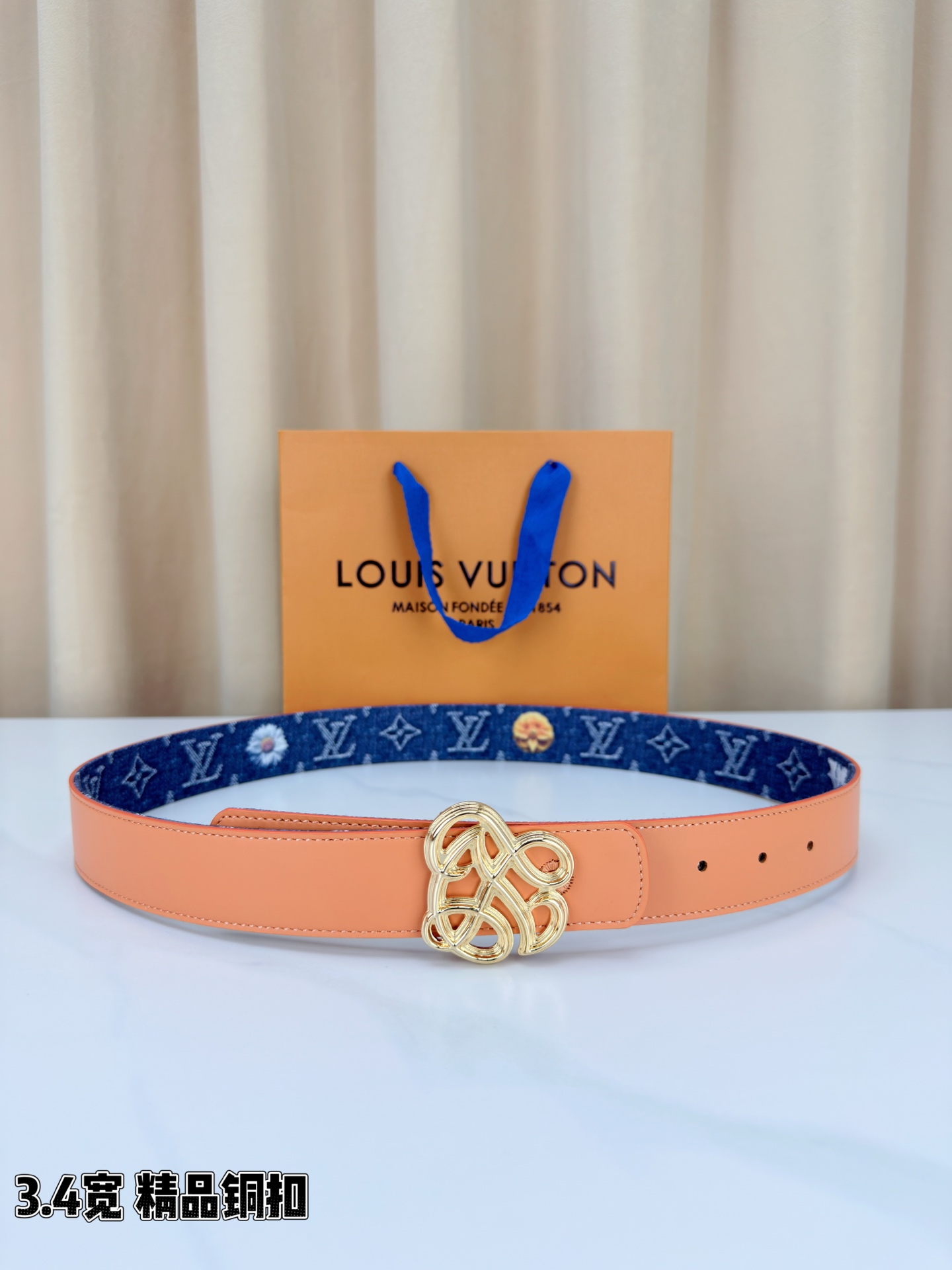 路易威登3.4宽腰带，深蓝牛仔肌理缀以橙黄花朵印花，法式浪漫悄然绽放。镂空铜扣线条交织，金银古白 古金 