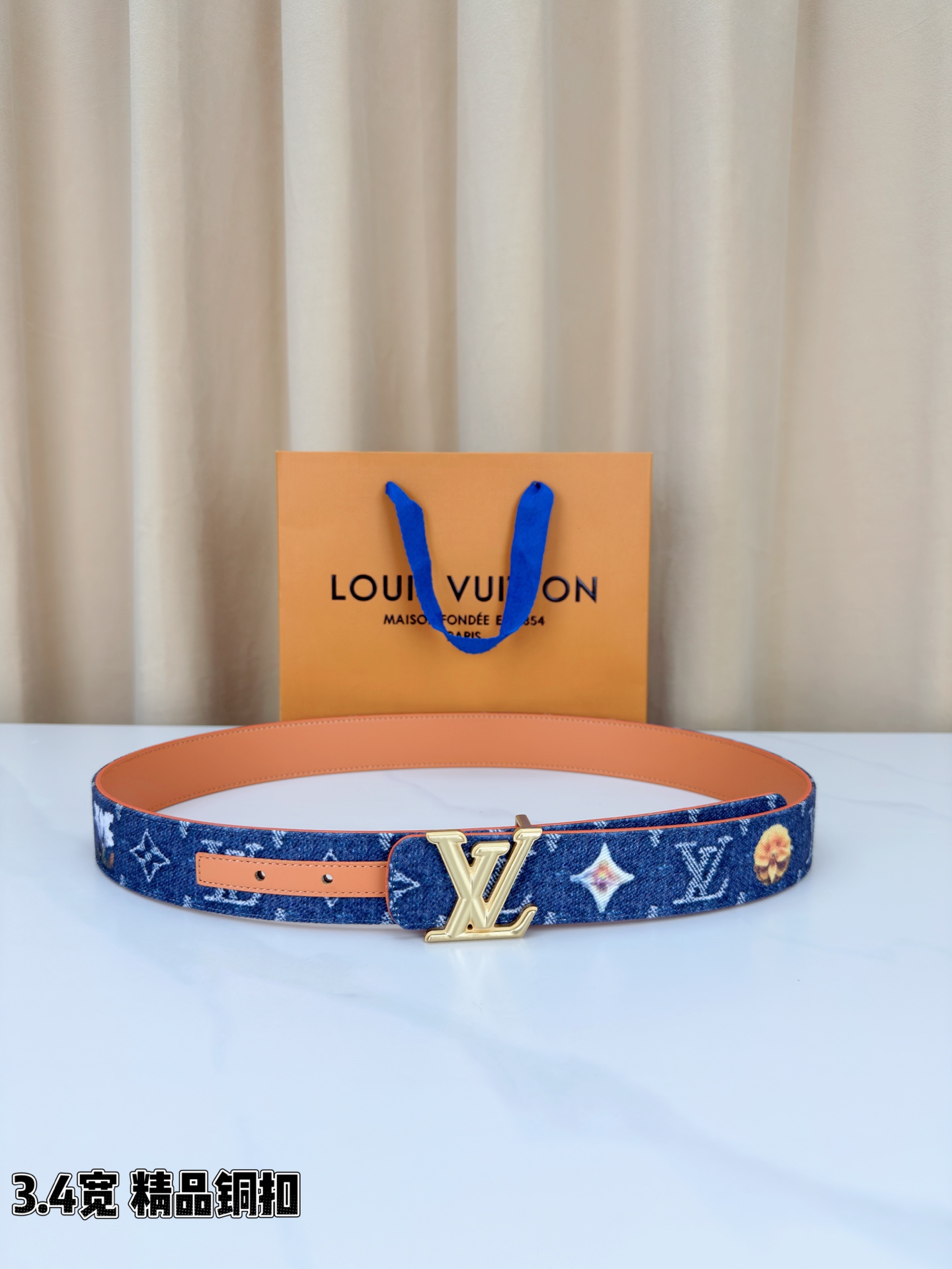 路易威登3.4宽腰带，深蓝牛仔肌理缀以花朵印花，法式浪漫悄然绽放。暖橙皮质内衬温柔贴肤，LV铜扣古白古金