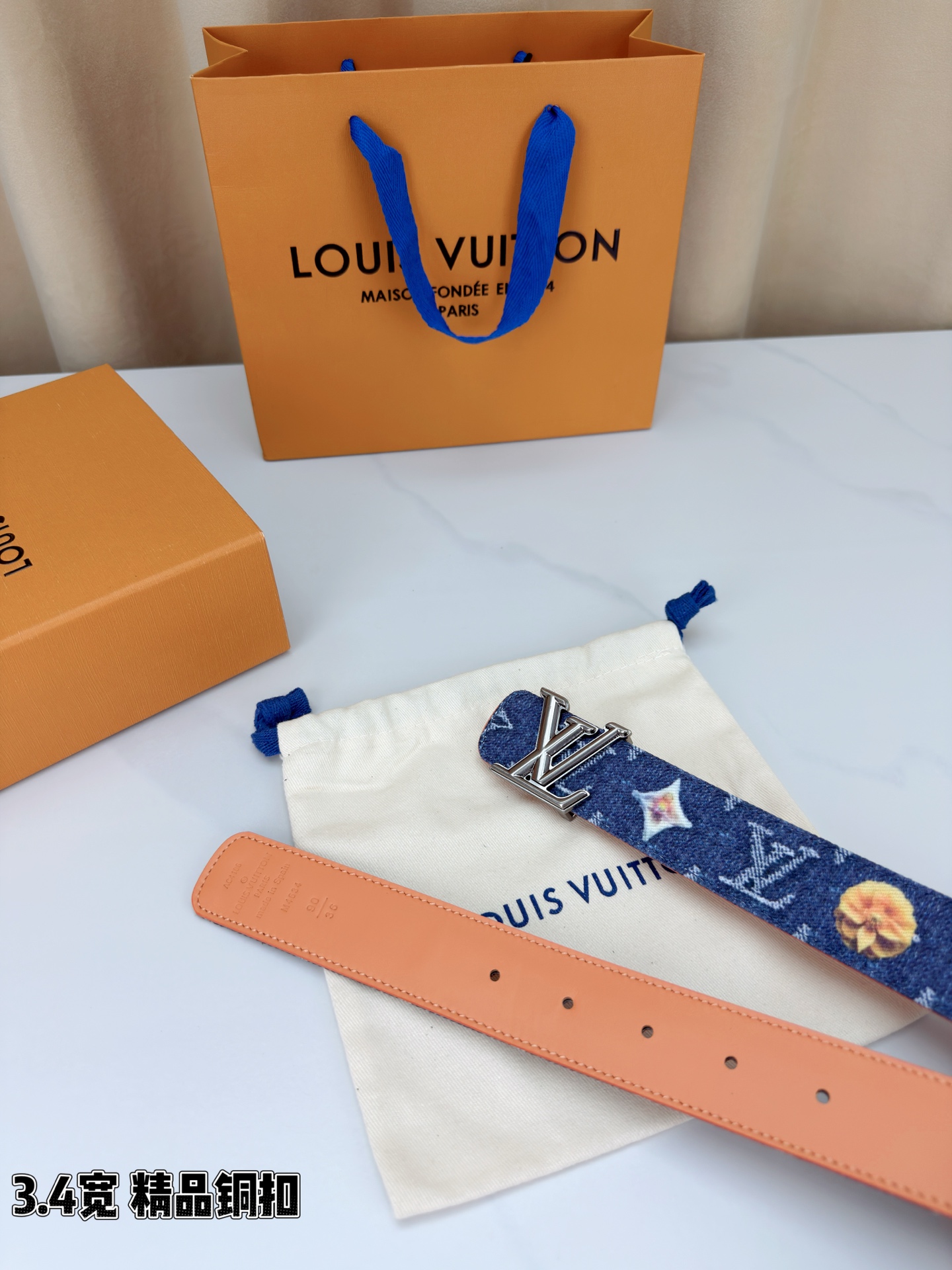 路易威登3.4宽腰带，深蓝牛仔肌理缀以花朵印花，法式浪漫悄然绽放。暖橙皮质内衬温柔贴肤，LV铜扣古白古金