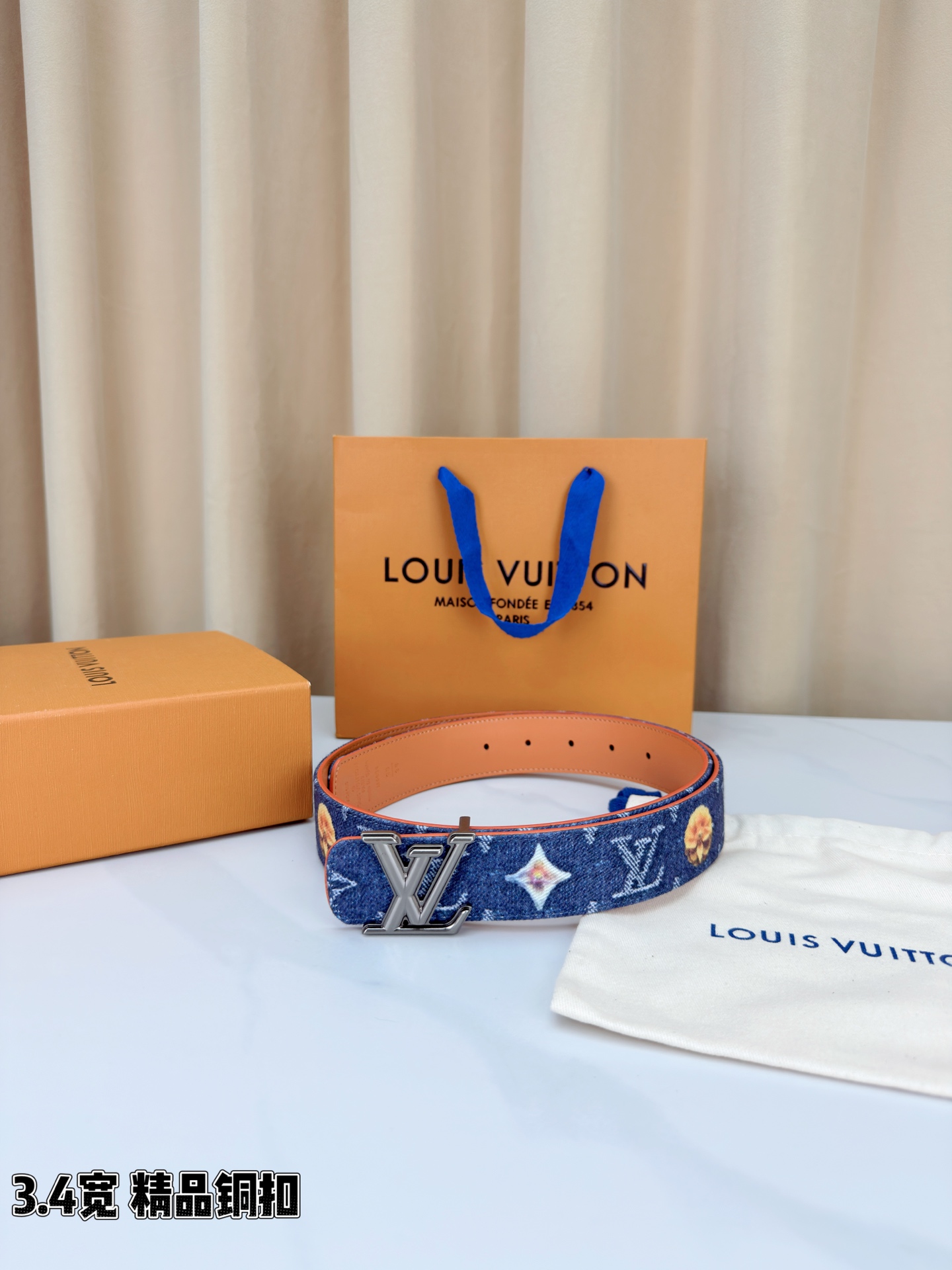 路易威登3.4宽腰带，深蓝牛仔肌理缀以花朵印花，法式浪漫悄然绽放。暖橙皮质内衬温柔贴肤，LV铜扣古白古金