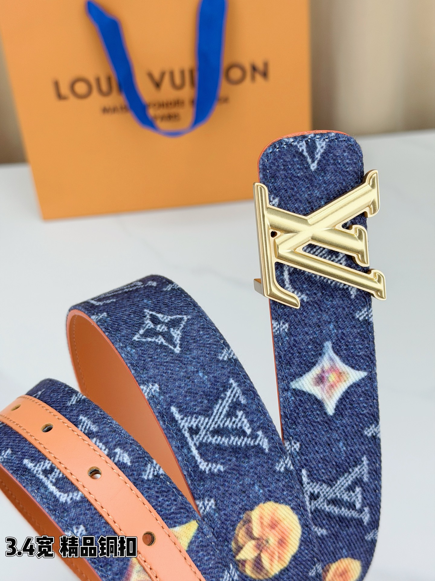 路易威登3.4宽腰带，深蓝牛仔肌理缀以花朵印花，法式浪漫悄然绽放。暖橙皮质内衬温柔贴肤，LV铜扣古白古金