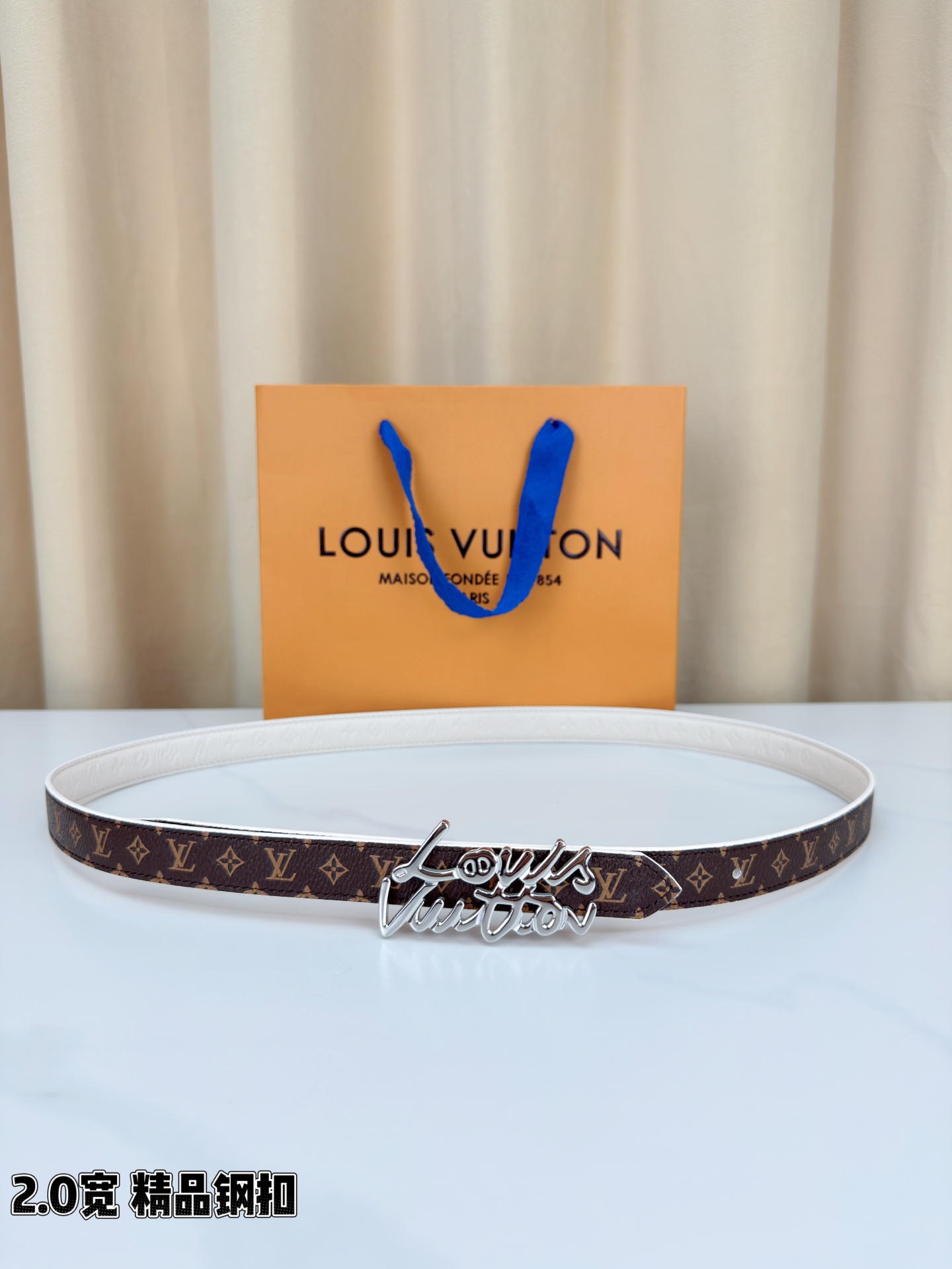 路易威登2.0宽细腰带，经典老花压纹悄然绽放，米白深棕双色可选。花体钢扣镌刻品牌之名，金银光泽温婉流转。