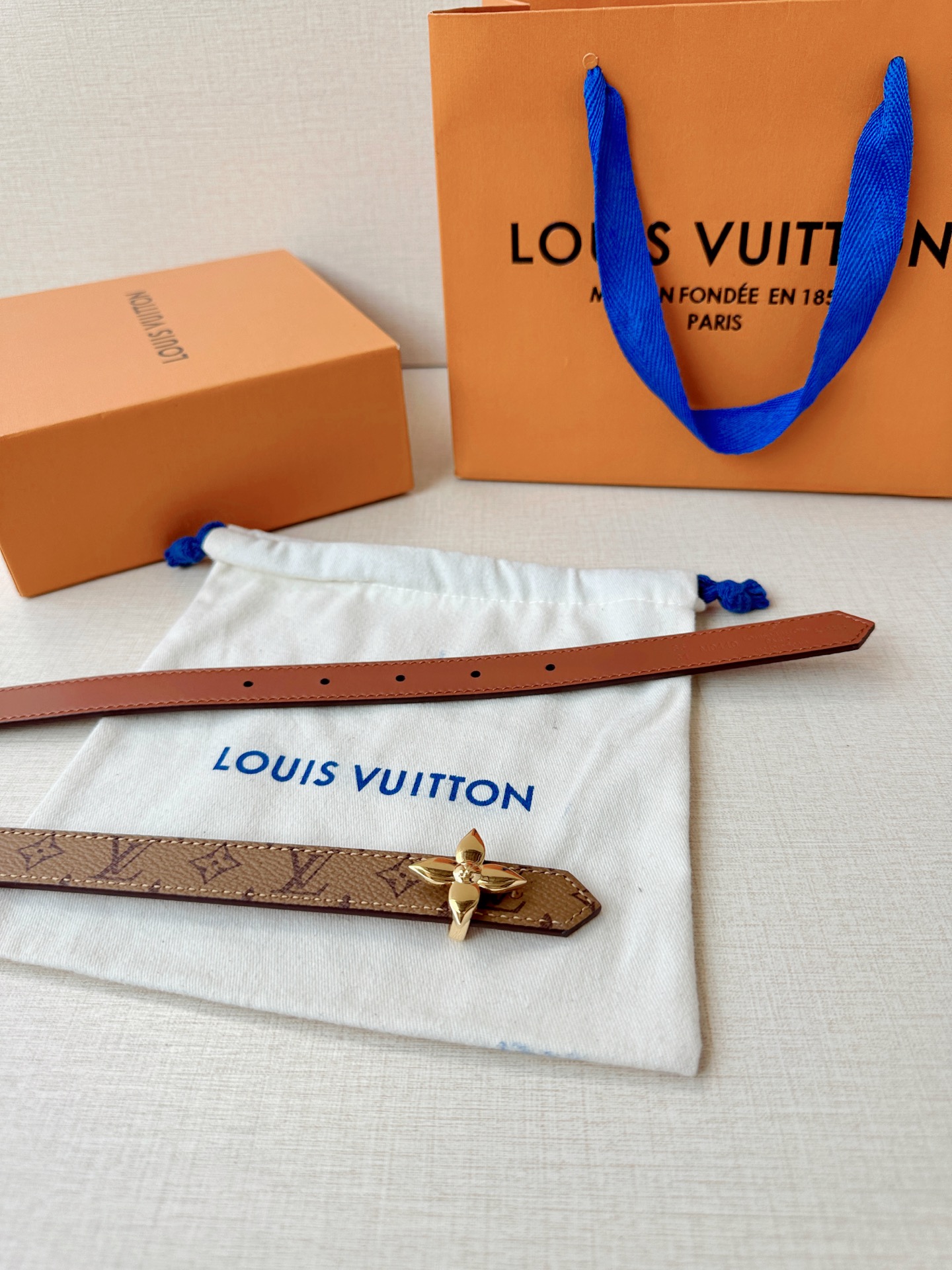 路易威登2.0宽精品铜扣老花腰带，经典老花邂逅四叶花扣，光影流转间熠熠生辉。深棕底色与浅金LV印记交织，