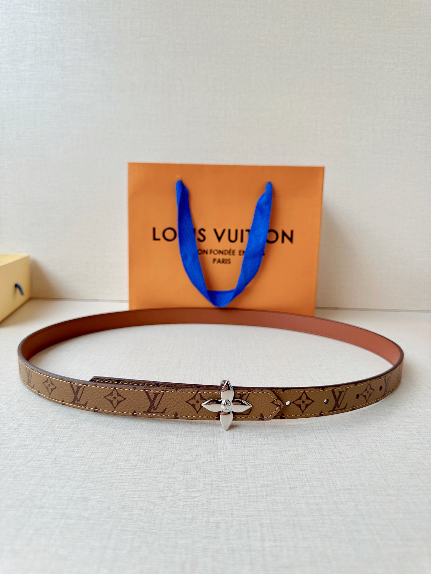 路易威登2.0宽精品铜扣老花腰带，经典老花邂逅四叶花扣，光影流转间熠熠生辉。深棕底色与浅金LV印记交织，