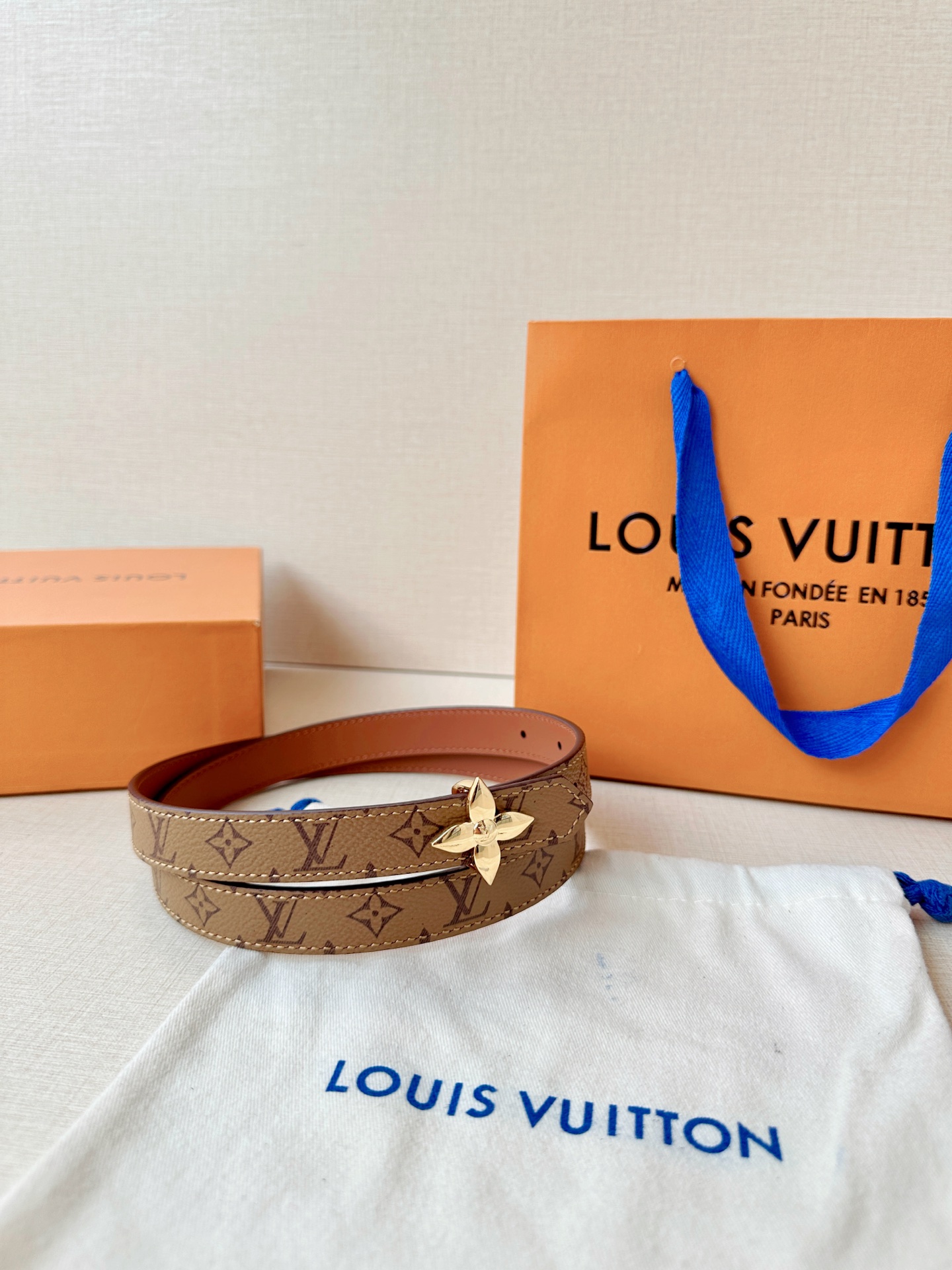 路易威登2.0宽精品铜扣老花腰带，经典老花邂逅四叶花扣，光影流转间熠熠生辉。深棕底色与浅金LV印记交织，