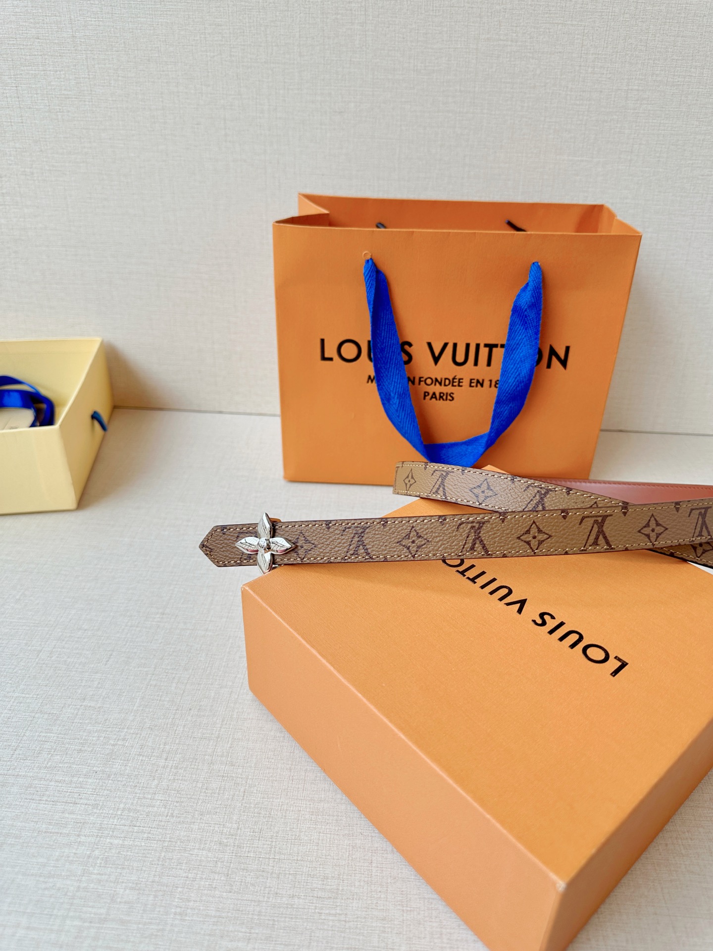 路易威登2.0宽精品铜扣老花腰带，经典老花邂逅四叶花扣，光影流转间熠熠生辉。深棕底色与浅金LV印记交织，