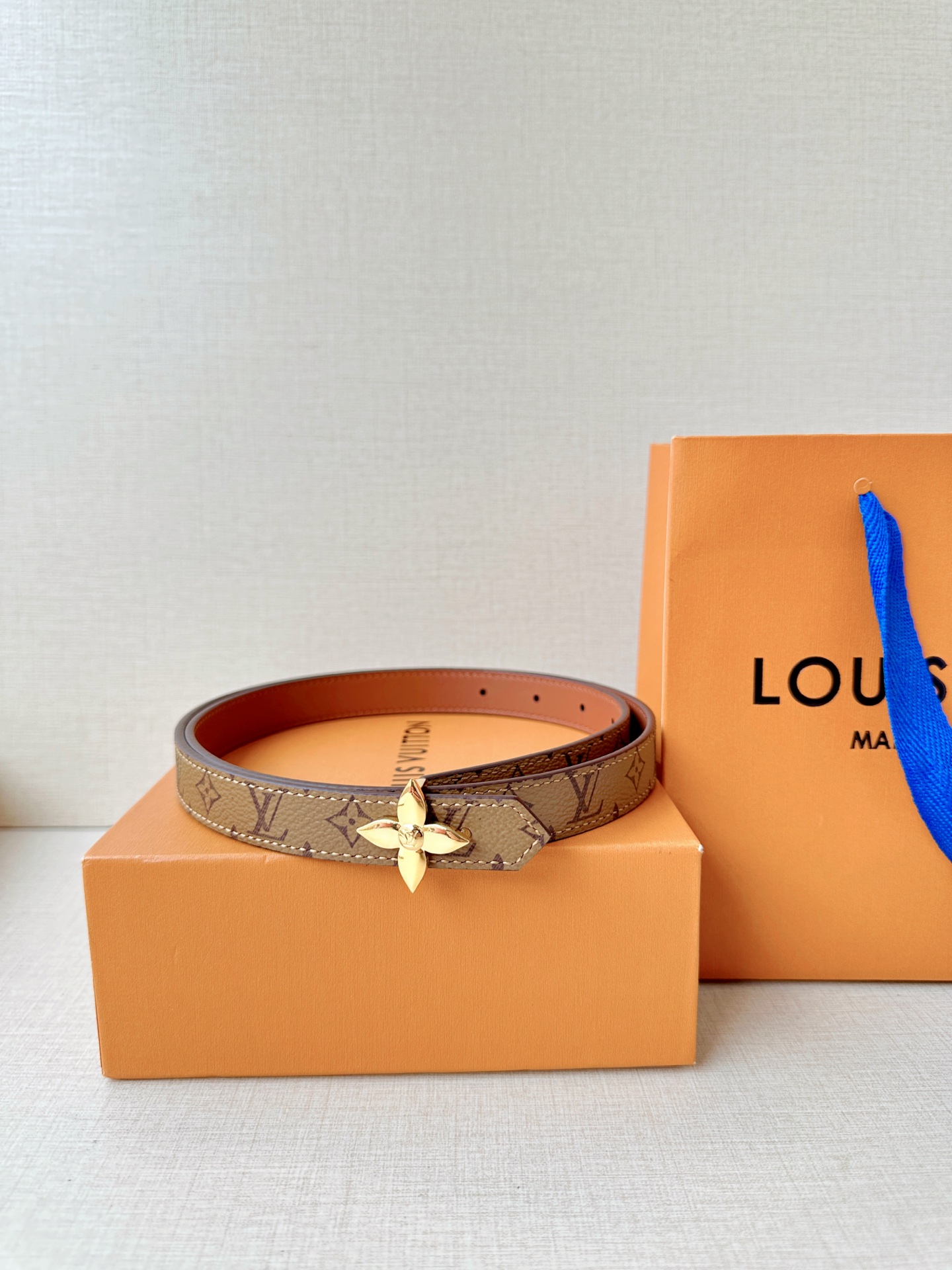 路易威登2.0宽精品铜扣老花腰带，经典老花邂逅四叶花扣，光影流转间熠熠生辉。深棕底色与浅金LV印记交织，