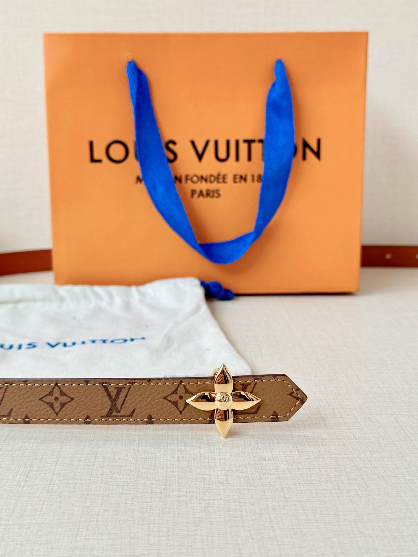 路易威登2.0宽精品铜扣老花腰带，经典老花邂逅四叶花扣，光影流转间熠熠生辉。深棕底色与浅金LV印记交织，