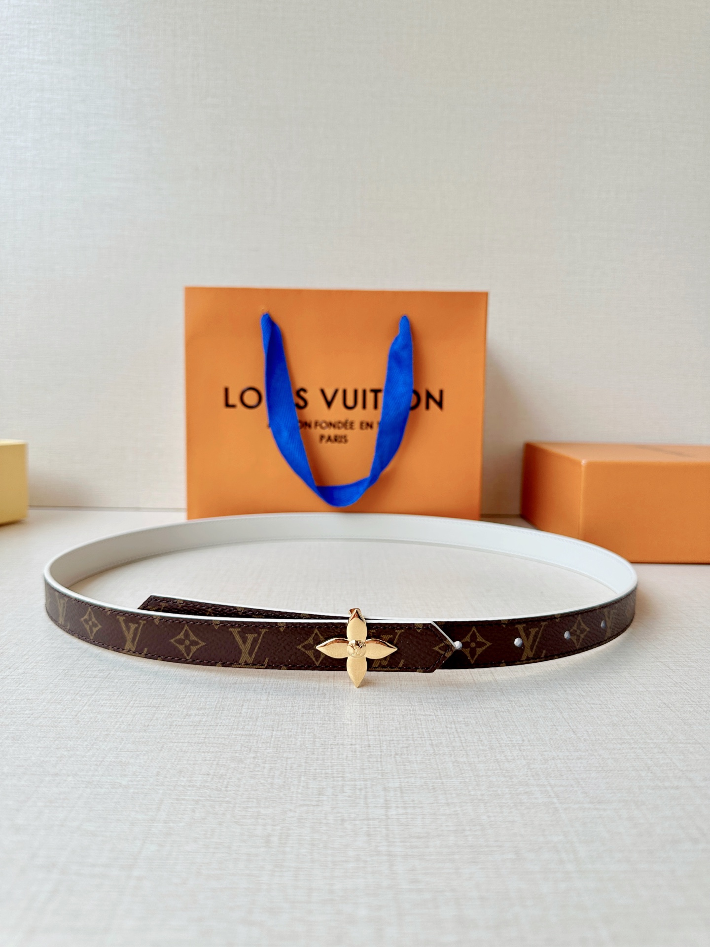 路易威登2.0宽精品铜扣老花腰带，经典老花邂逅四叶花扣，光影流转间熠熠生辉。深棕底色与浅金LV印记交织，