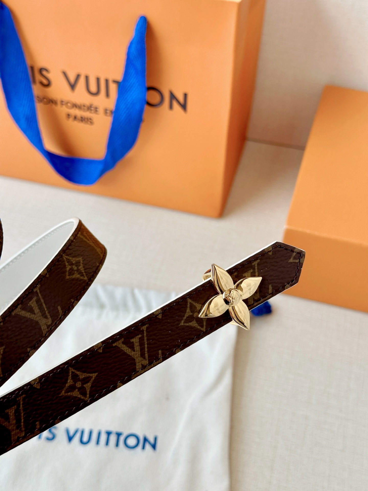 路易威登2.0宽精品铜扣老花腰带，经典老花邂逅四叶花扣，光影流转间熠熠生辉。深棕底色与浅金LV印记交织，