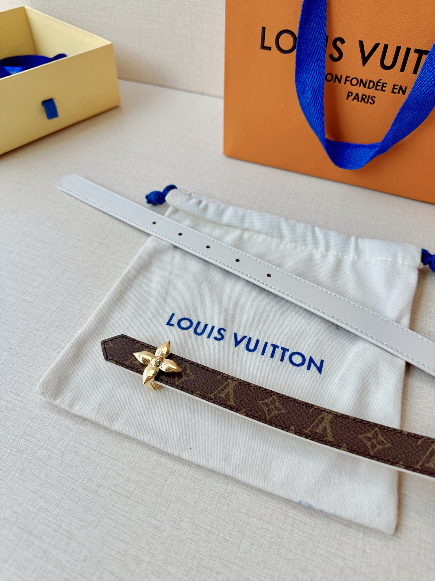 路易威登2.0宽精品铜扣老花腰带，经典老花邂逅四叶花扣，光影流转间熠熠生辉。深棕底色与浅金LV印记交织，