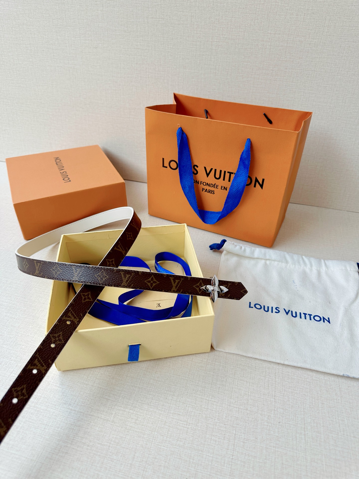 路易威登2.0宽精品铜扣老花腰带，经典老花邂逅四叶花扣，光影流转间熠熠生辉。深棕底色与浅金LV印记交织，