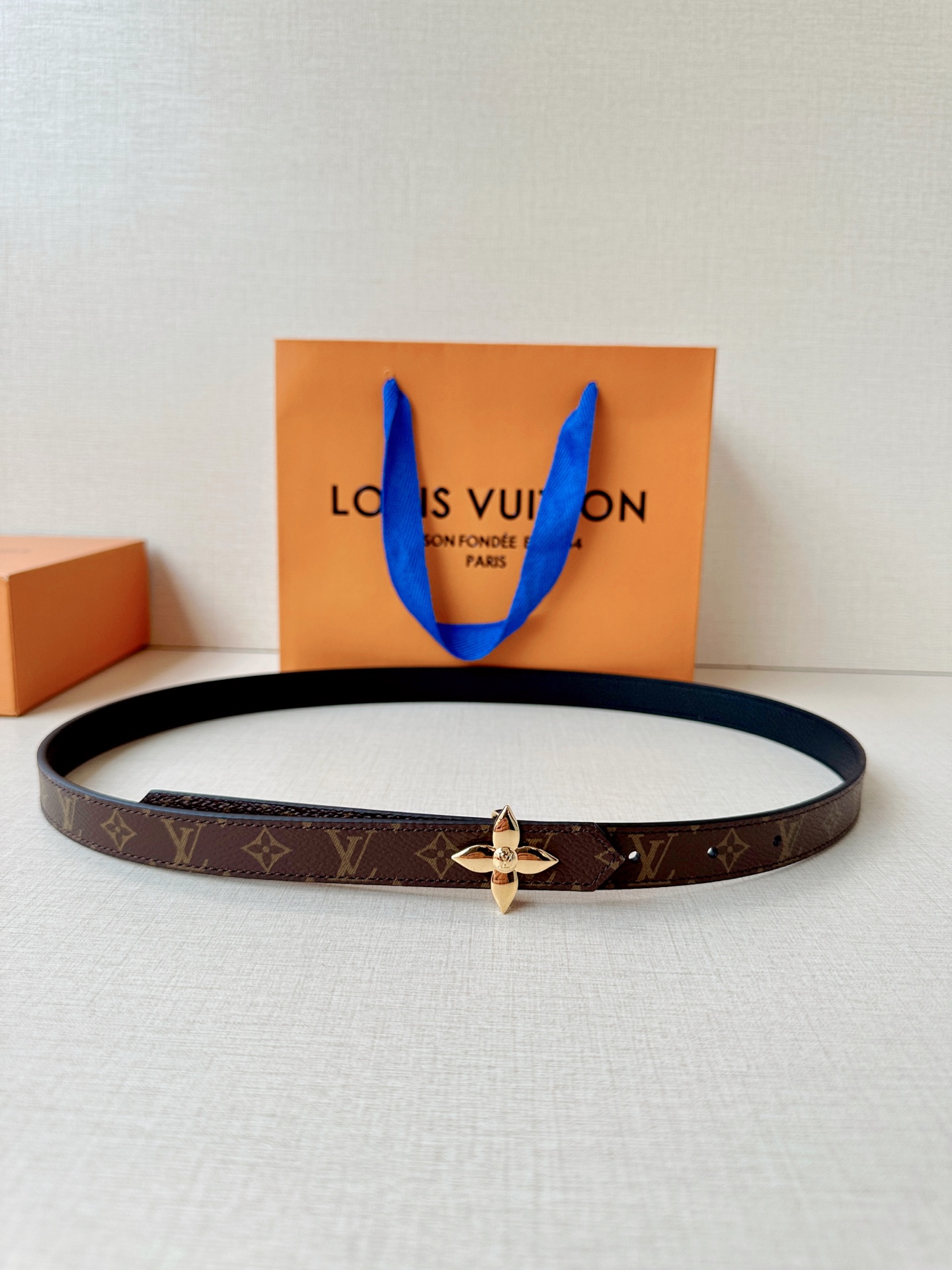 路易威登2.0宽精品铜扣老花腰带，经典老花邂逅四叶花扣，光影流转间熠熠生辉。深棕底色与浅金LV印记交织，