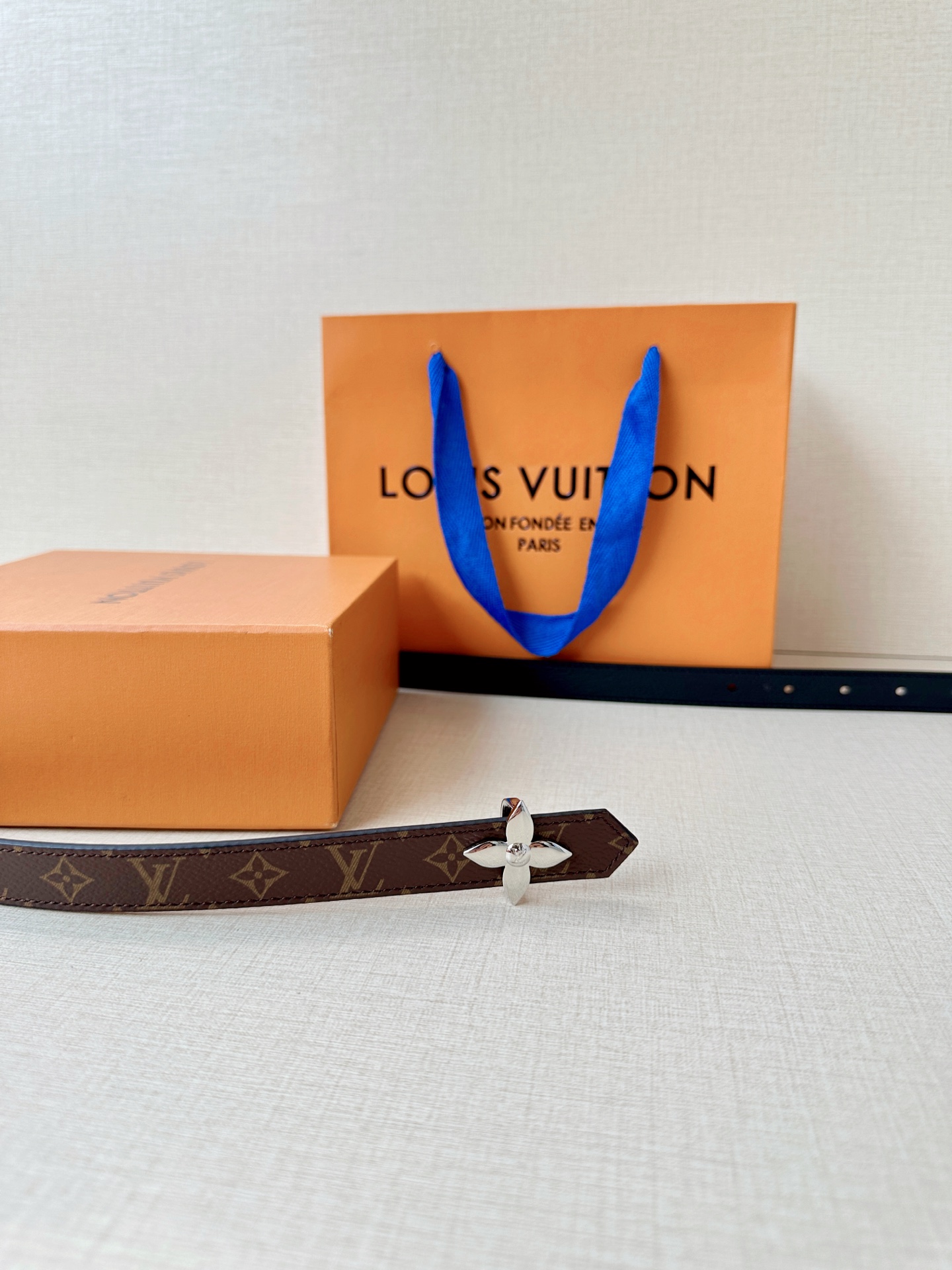 路易威登2.0宽精品铜扣老花腰带，经典老花邂逅四叶花扣，光影流转间熠熠生辉。深棕底色与浅金LV印记交织，