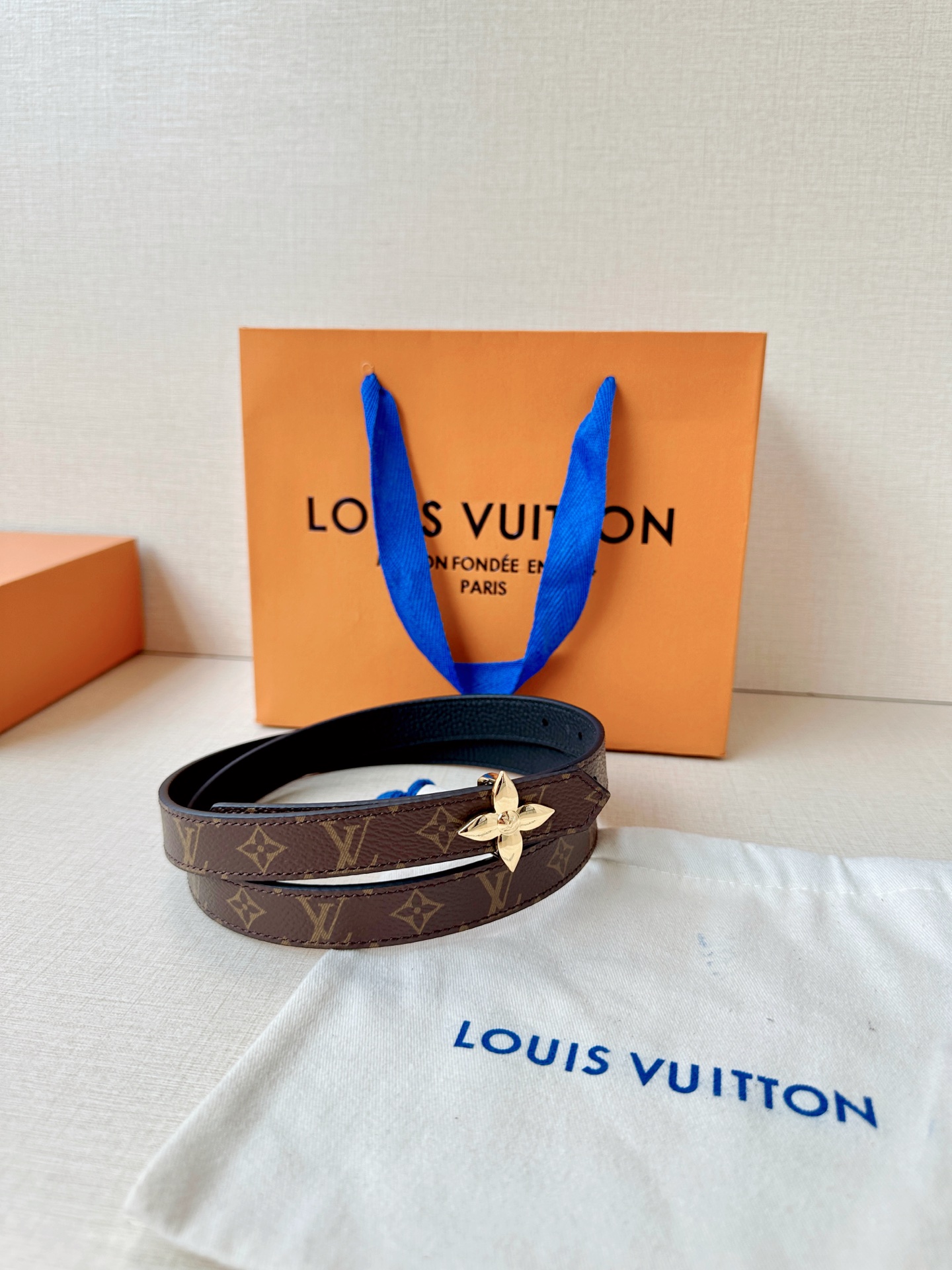 路易威登2.0宽精品铜扣老花腰带，经典老花邂逅四叶花扣，光影流转间熠熠生辉。深棕底色与浅金LV印记交织，