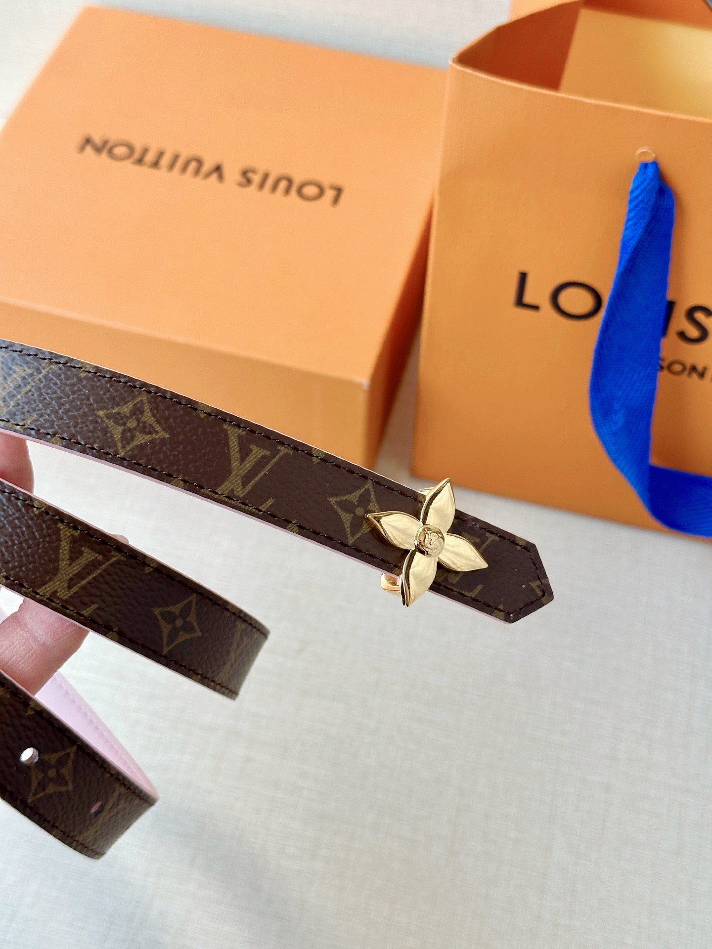 路易威登2.0宽精品铜扣老花腰带，经典老花邂逅四叶花扣，光影流转间熠熠生辉。深棕底色与浅金LV印记交织，