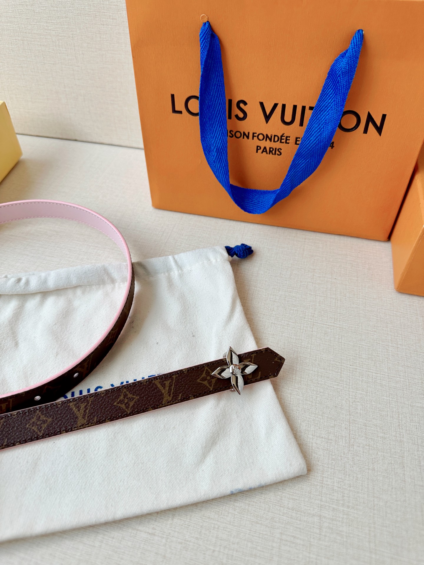 路易威登2.0宽精品铜扣老花腰带，经典老花邂逅四叶花扣，光影流转间熠熠生辉。深棕底色与浅金LV印记交织，