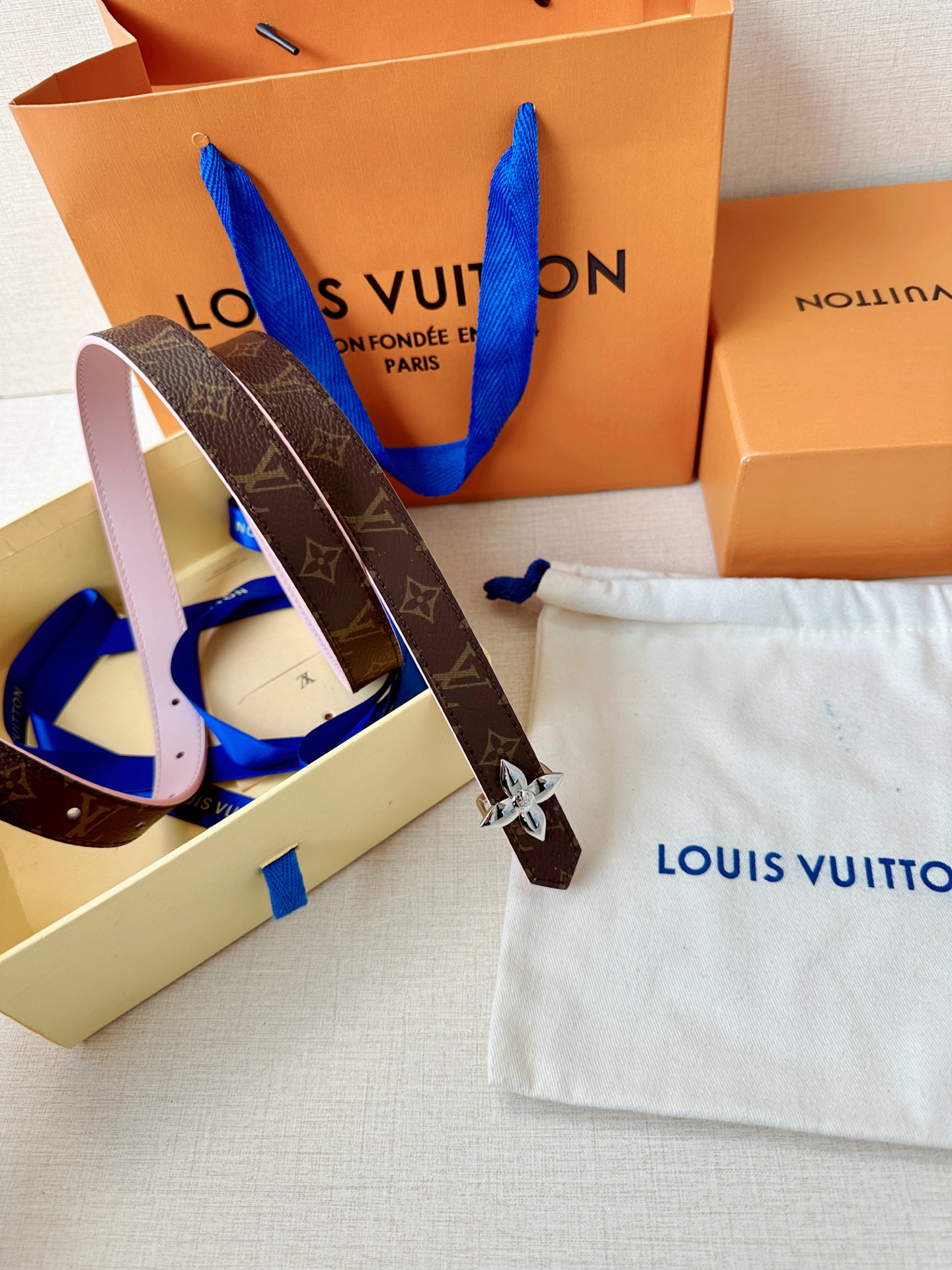 路易威登2.0宽精品铜扣老花腰带，经典老花邂逅四叶花扣，光影流转间熠熠生辉。深棕底色与浅金LV印记交织，