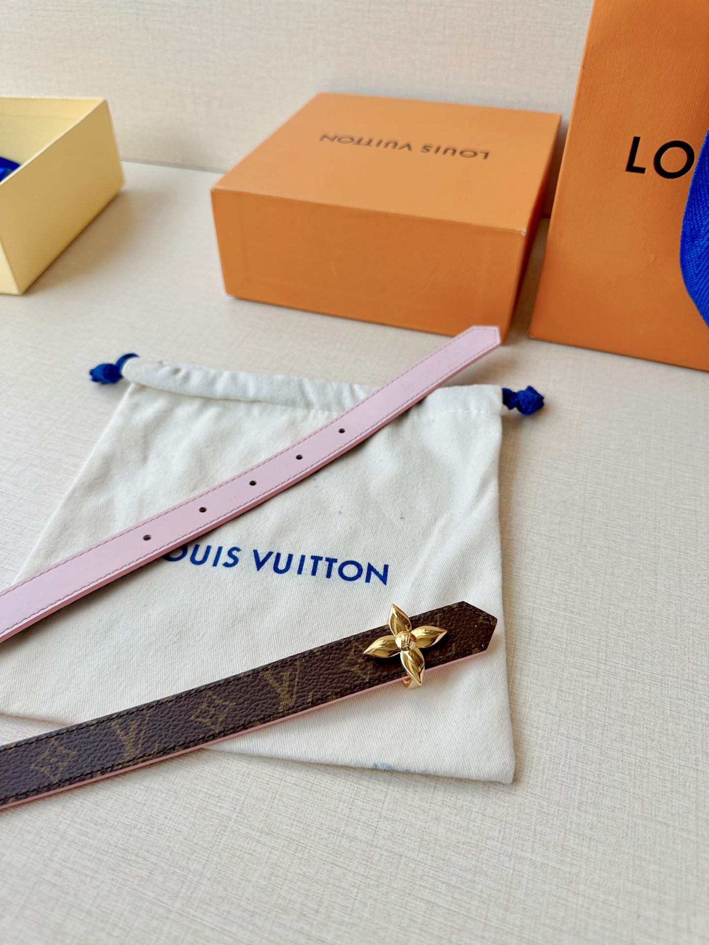 路易威登2.0宽精品铜扣老花腰带，经典老花邂逅四叶花扣，光影流转间熠熠生辉。深棕底色与浅金LV印记交织，