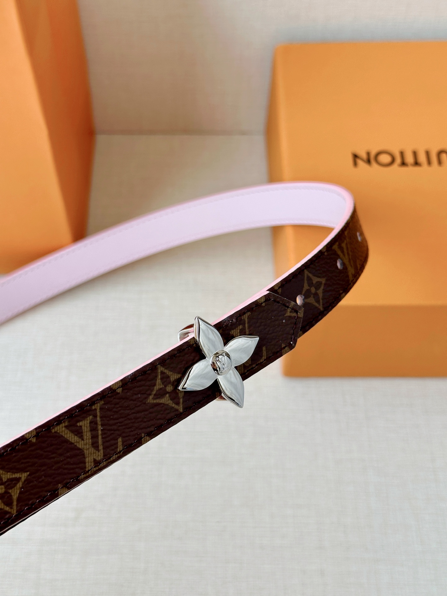 路易威登2.0宽精品铜扣老花腰带，经典老花邂逅四叶花扣，光影流转间熠熠生辉。深棕底色与浅金LV印记交织，