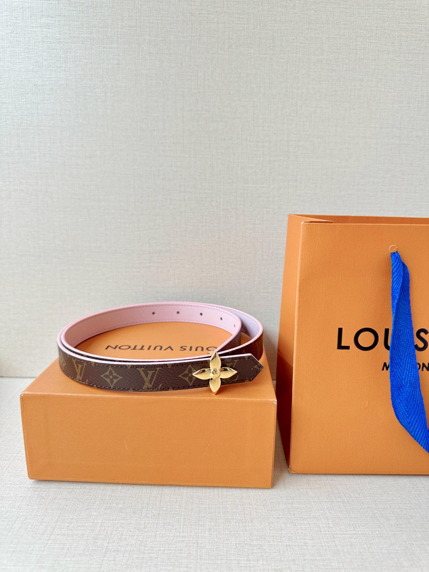 路易威登2.0宽精品铜扣老花腰带，经典老花邂逅四叶花扣，光影流转间熠熠生辉。深棕底色与浅金LV印记交织，