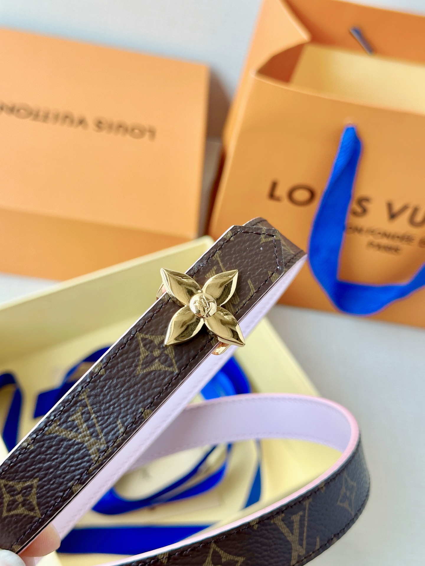 路易威登2.0宽精品铜扣老花腰带，经典老花邂逅四叶花扣，光影流转间熠熠生辉。深棕底色与浅金LV印记交织，