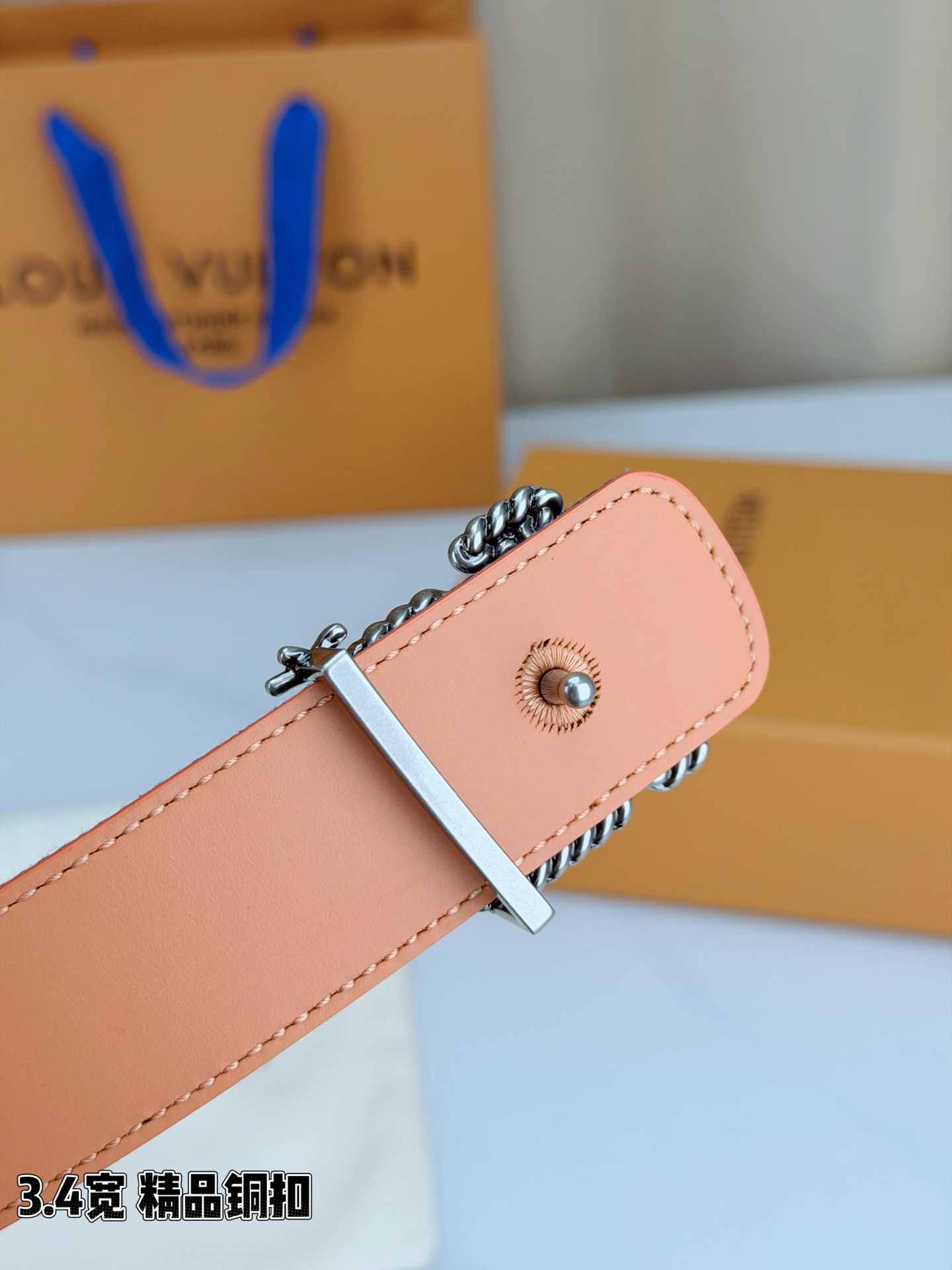 路易威登3.4宽精品铜扣腰带，深蓝牛仔邂逅暖橙皮革，双面风情随心切换。金色扭绳LV扣熠熠生辉，银链V形扣