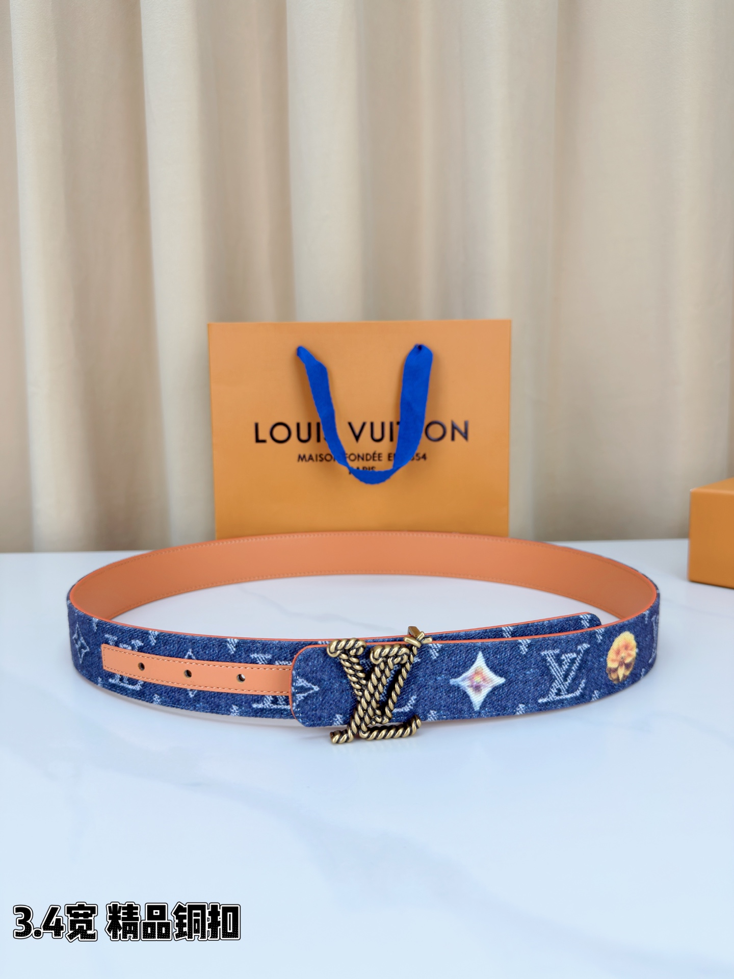 路易威登3.4宽精品铜扣腰带，深蓝牛仔邂逅暖橙皮革，双面风情随心切换。金色扭绳LV扣熠熠生辉，银链V形扣