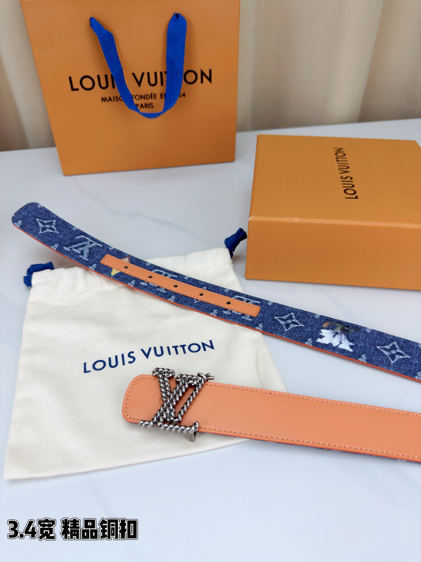 路易威登3.4宽精品铜扣腰带，深蓝牛仔邂逅暖橙皮革，双面风情随心切换。金色扭绳LV扣熠熠生辉，银链V形扣