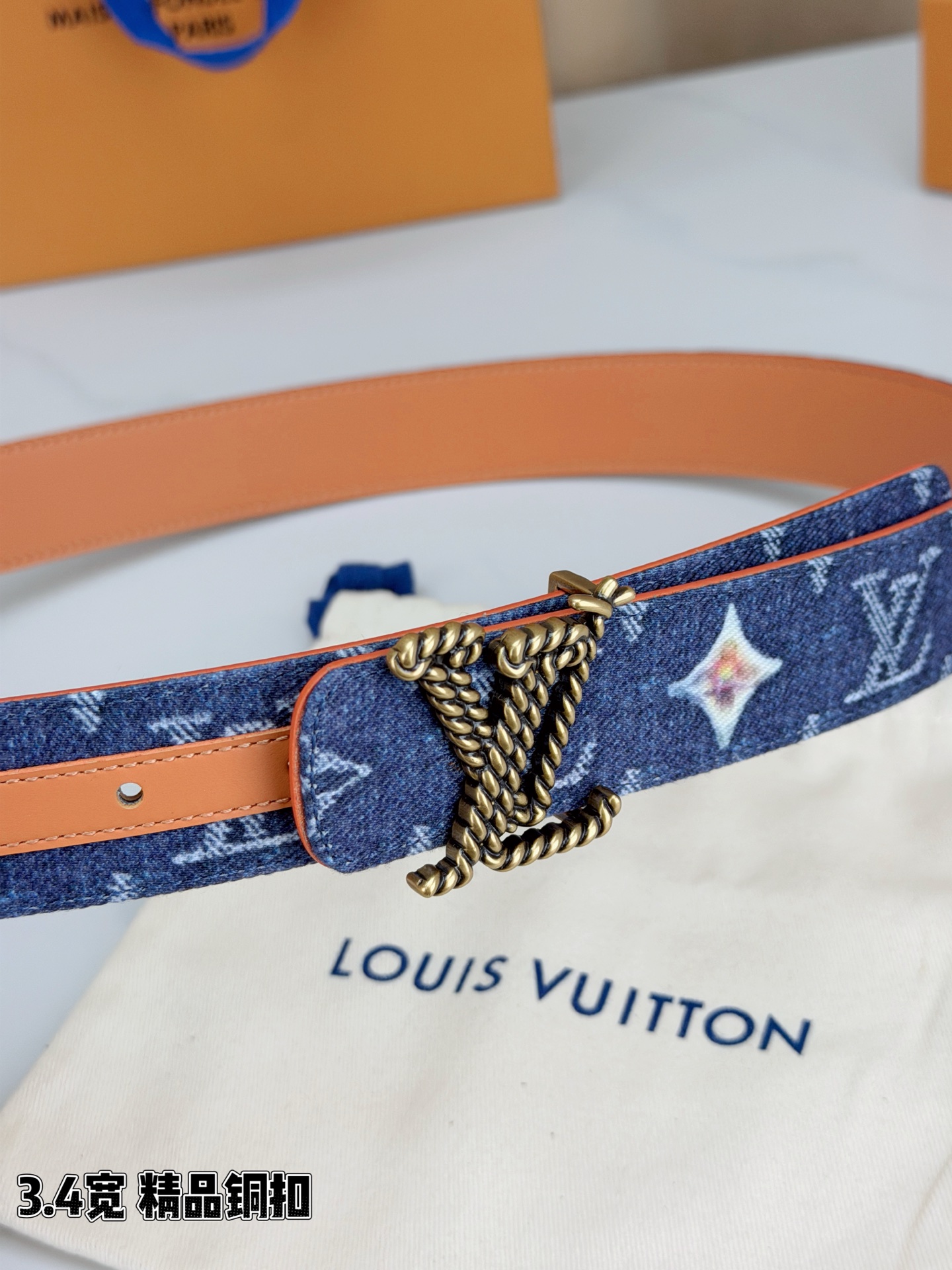 路易威登3.4宽精品铜扣腰带，深蓝牛仔邂逅暖橙皮革，双面风情随心切换。金色扭绳LV扣熠熠生辉，银链V形扣